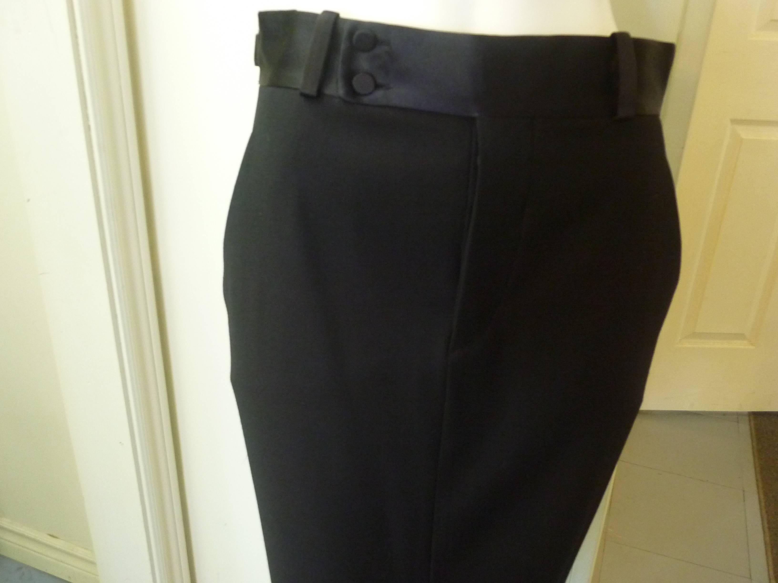 This maxi skirt is an elegant addition to any evening wardrobe. It is made of wool with a satin band at the waist as well as the sides. Closure is by way of hidden satin covered buttons at the front. There are also two button down pockets on the