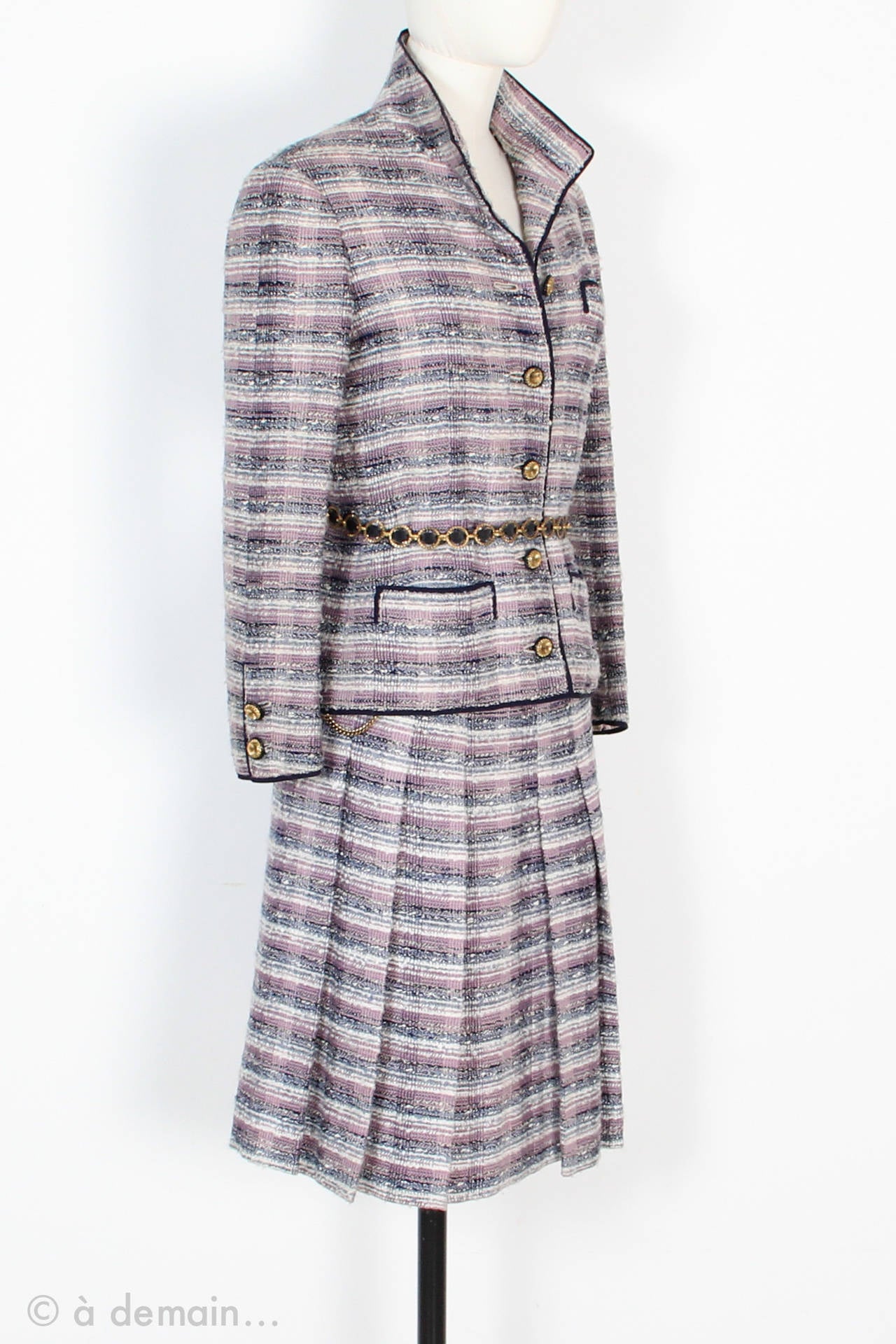 Typical 70s Chanel Haute Couture Set made of striped wool in purple tones. 
The set is entirely lined with pink silk. French size 38.

Jacket description:
Three real small pockets on the jacket, one on the chest and two on the bottom front. Gold