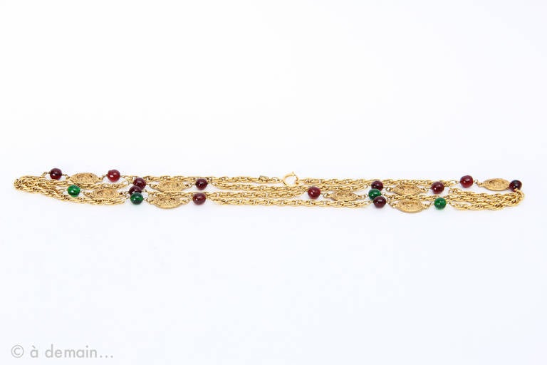 Extra Long Chanel Sautoir Necklace of golden links embellished with red and green molten glass pearls and labelled ovale medallions from 1980s / 90s.

Total length: 200 cm