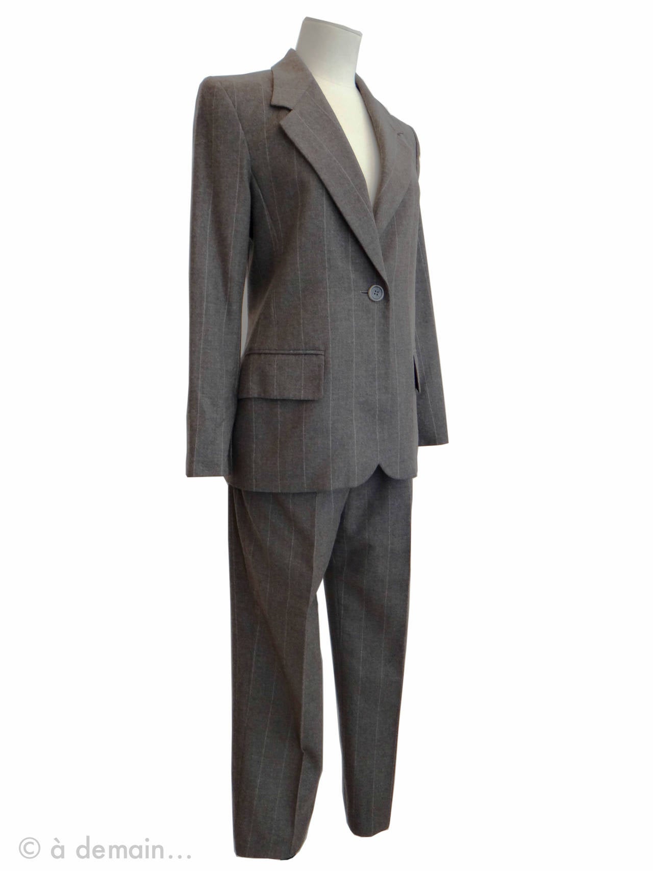 Striped Gray Trouser Suit by Yves Saint Laurent Rive Gauche, made of wool and cashmere, indicated size 36.

Jacket with shoulder pads
Shoulders: 39 cm
Armpits: 40 cm
Bottom: 52 cm
Total height: 70 cm

Trousers
Waist: 33 cm
Total height: