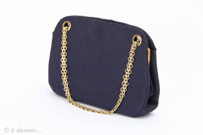 Chanel Handbag in dark blue quilted fabric, red fabric inside and golden metal strap.
W: 24 cm
D: 5,5 cm
H: 15 cm