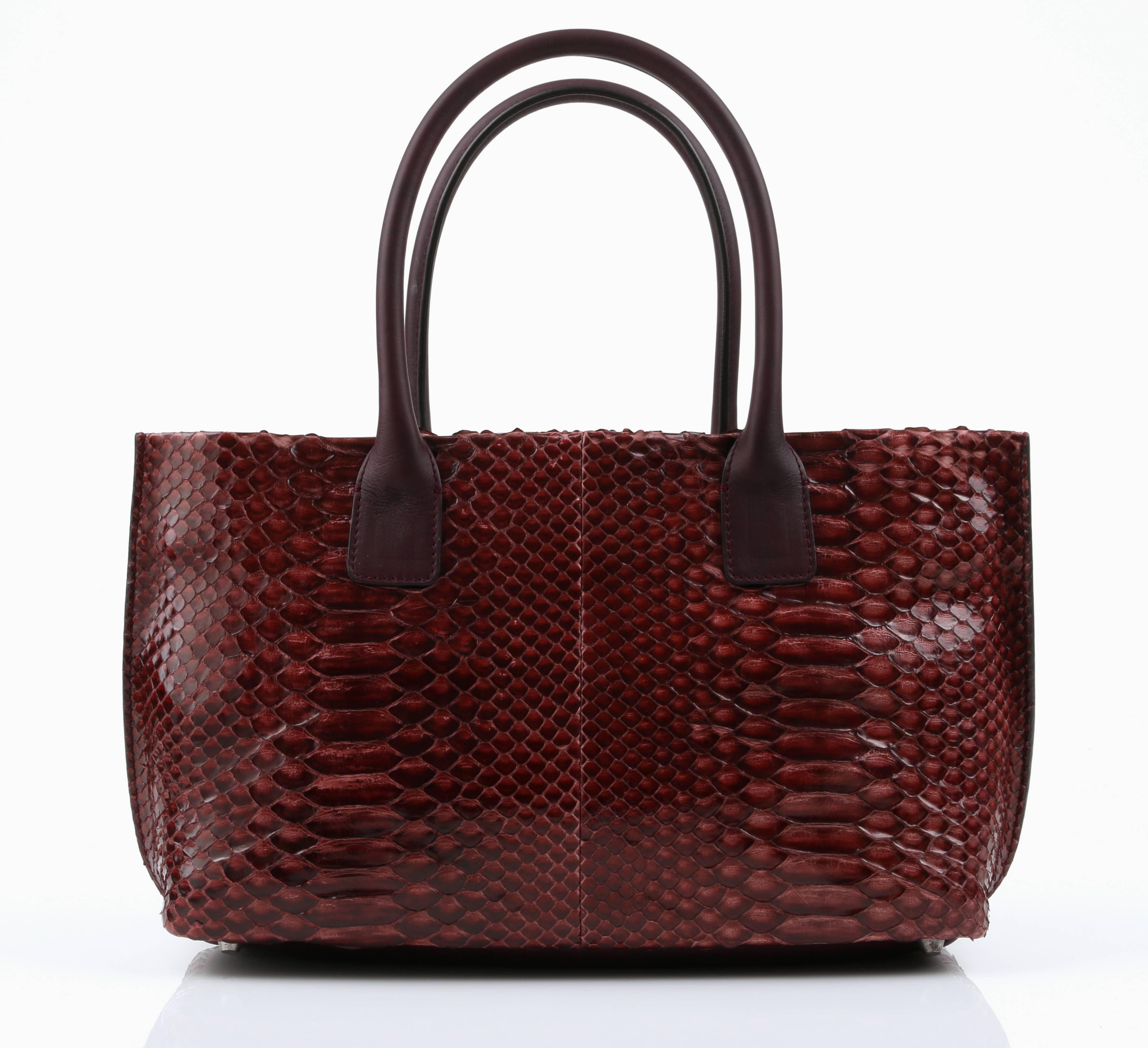 New Brunello Cucinelli burgundy red genuine python satchel purse. Body of the bag is a polished python snakeskin, with the sides, bottom and rolled handle straps a deep burgundy leather. Interior and top is a gray wool/cashmere. Silver-tone