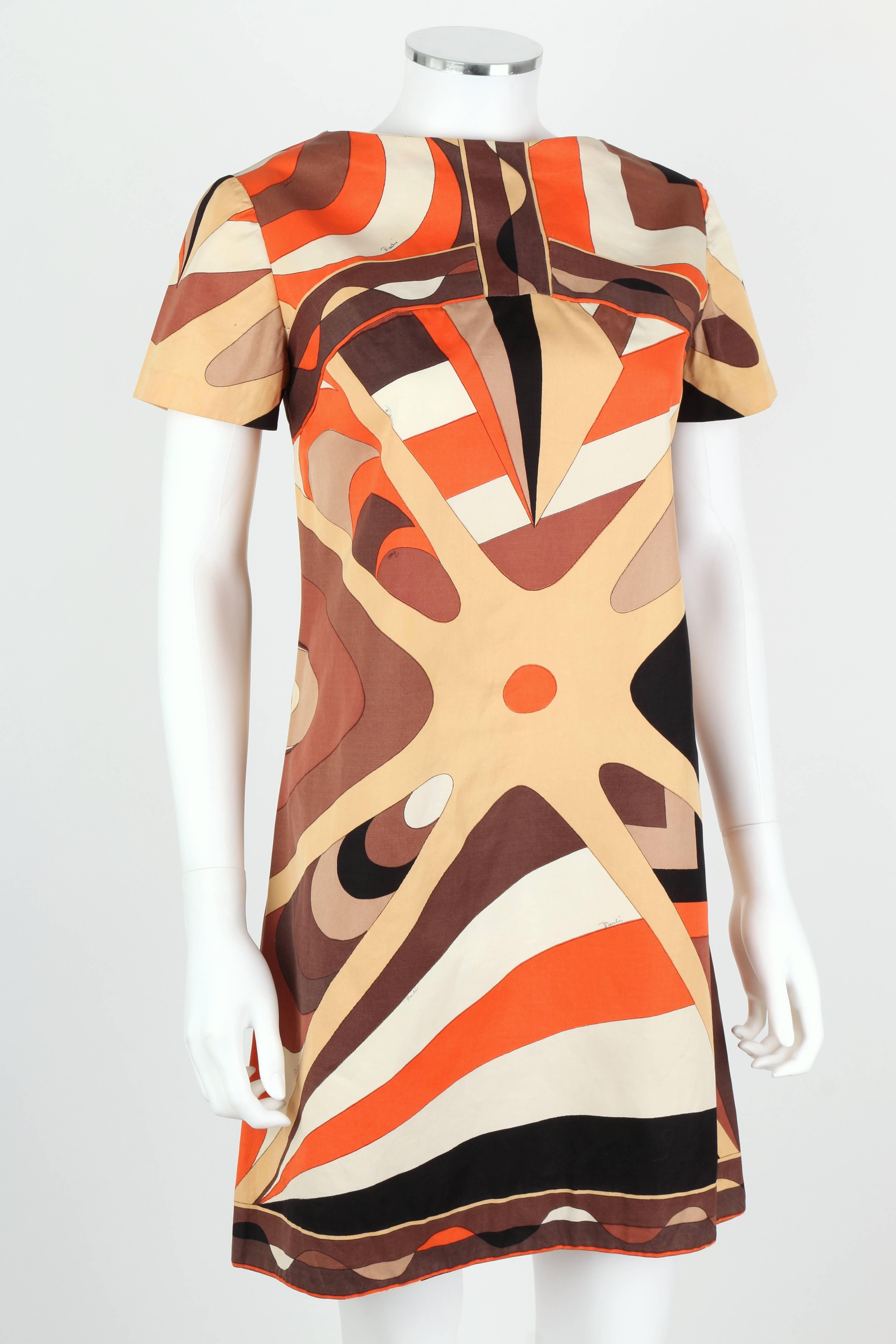 Vintage c.1960s Emilio Pucci for Neiman Marcus shift dress. All over brown, beige, and orange abstract op art signature print. Short sleeves. Bateau neckline. Center button closure at back. Please note that this item was pinned to better fit our