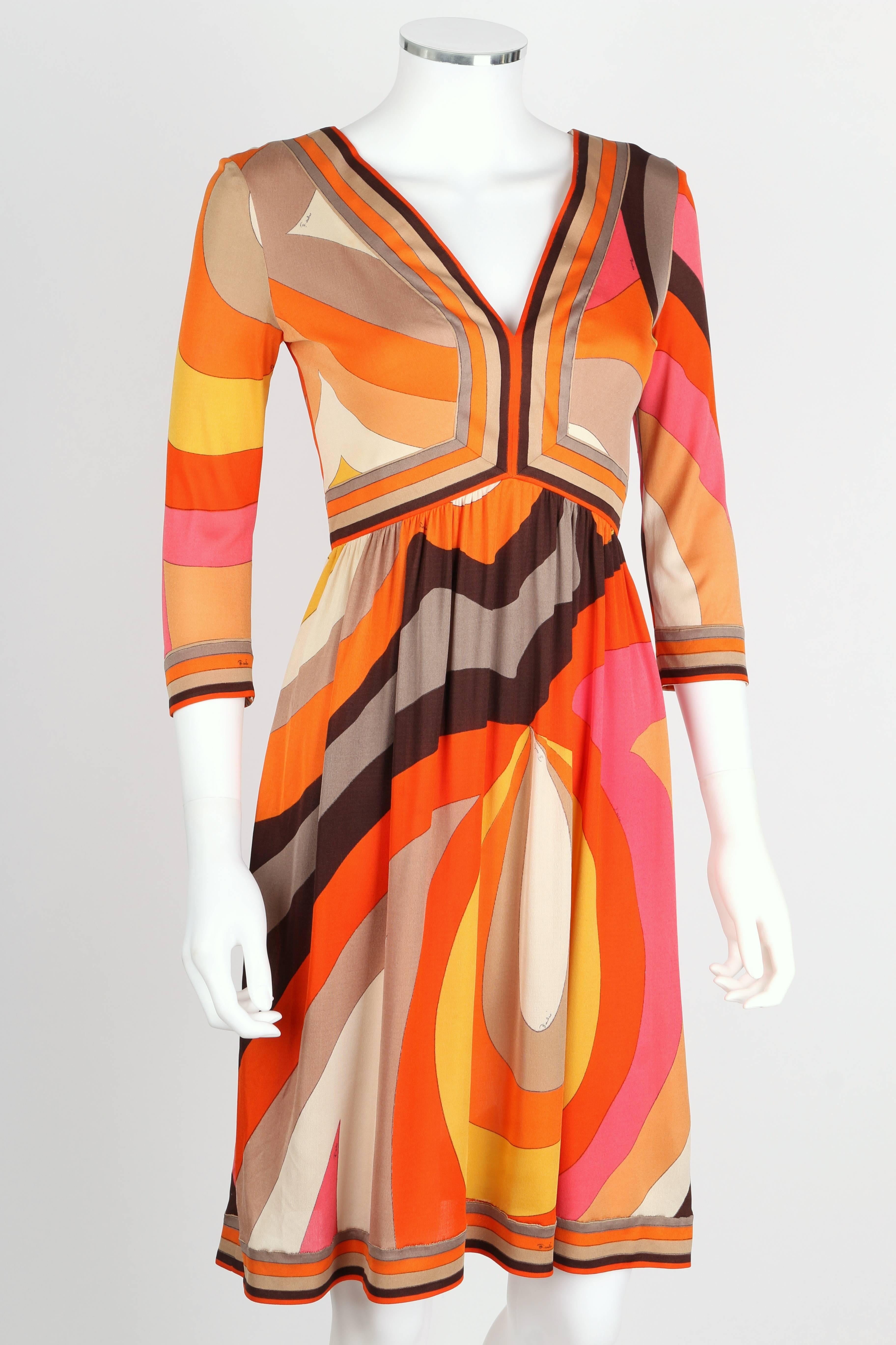 Vintage c.1960s Emilio Pucci orange, pink, brown, gold, and ivory abstract signature print silk jersey dress. Empire waist. V-neckline at front. Three-quarter length sleeves. Above the knee length. Center back zipper closure. Marked Fabric Content: