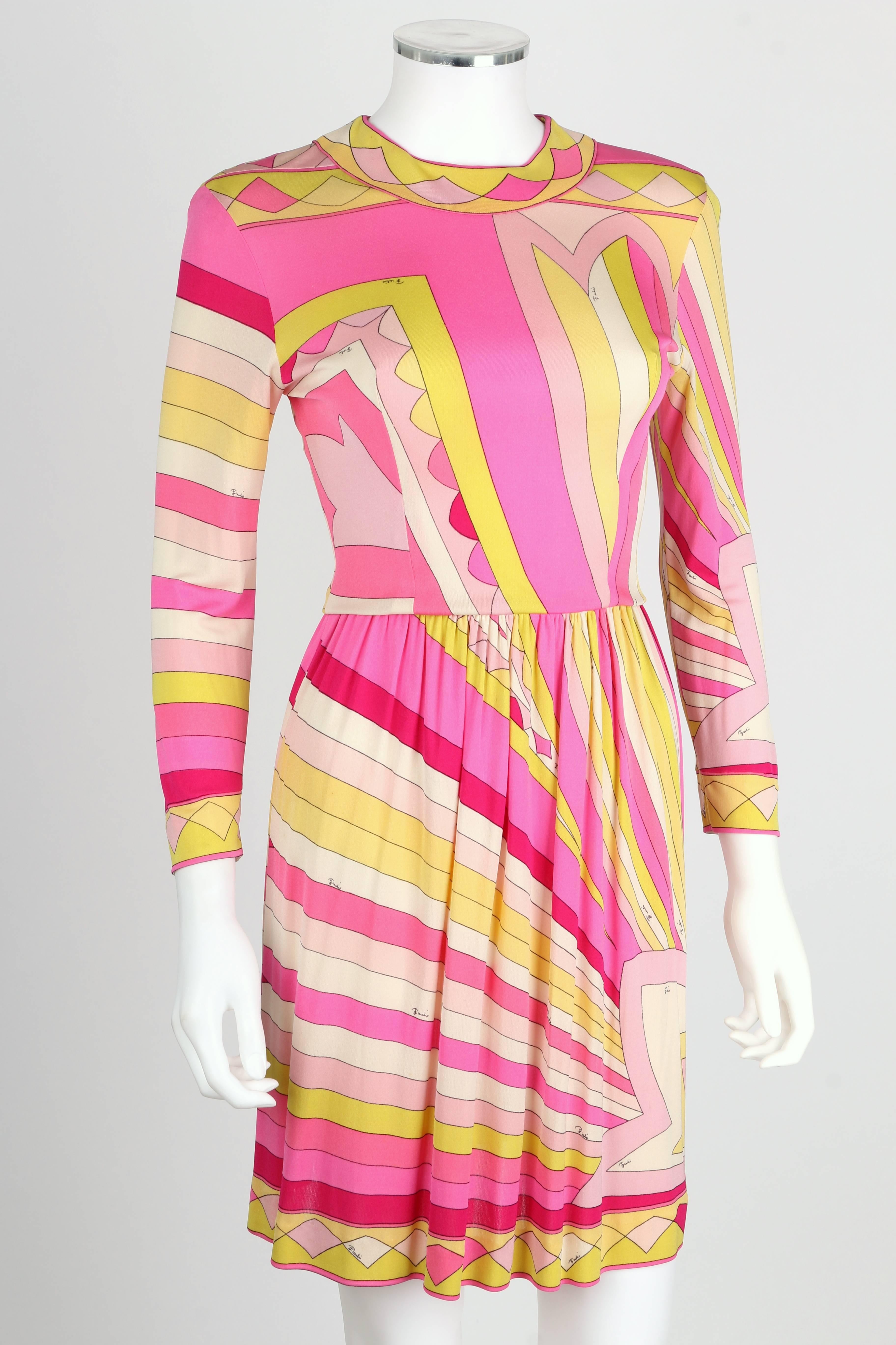 Vintage Kleid aus Seidenjersey von Emilio Pucci aus den 1960er Jahren. All-Over-Sunburst-Signaturdruck in Rosa-, Gelb- und Weißtönen. Dekorative Borte an Manschetten, Halsausschnitt und Saum. Runder Ausschnitt. Ärmel in Handgelenklänge.