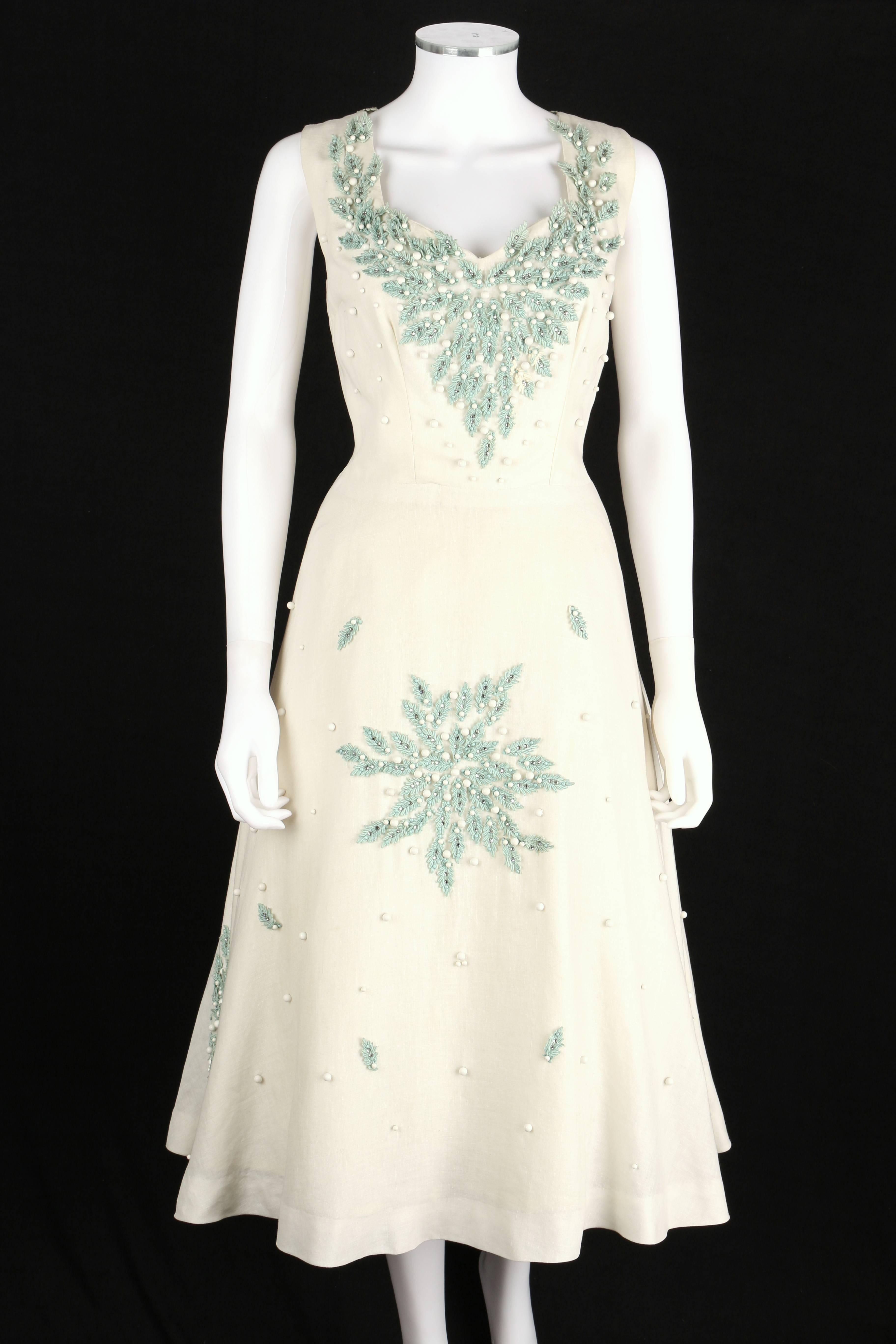 Vintage c.1950s Milton Saunders Original white/ivory linen tea length party dress. Sweetheart neckline front and back. Embellished throughout with turquoise applique leaves, white and turquoise studs and rhinestones. Closes at side with metal