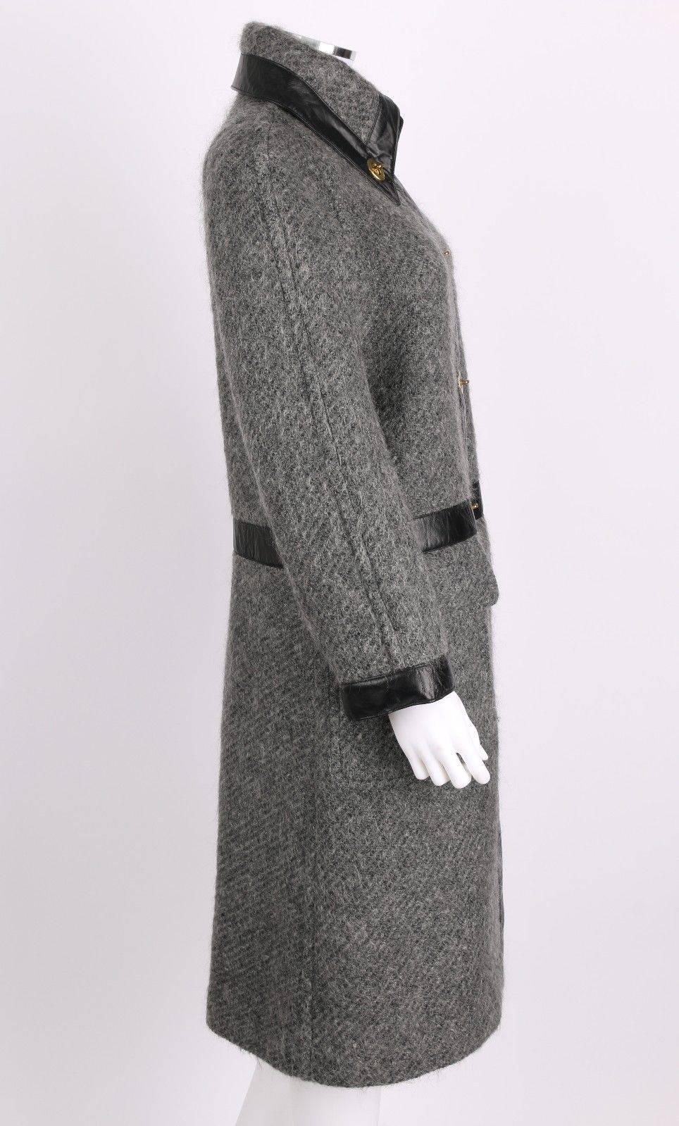 Vintage c.1960s Bonnie Cashin for Sills gray wool-mohair coat. Black leather trim on collar, waist, closure, and cuffs.. Two large patch pockets. Front center closure with coach-style turn-lock. Turn-lock on collar. Midi Length. Unmarked Fabric: