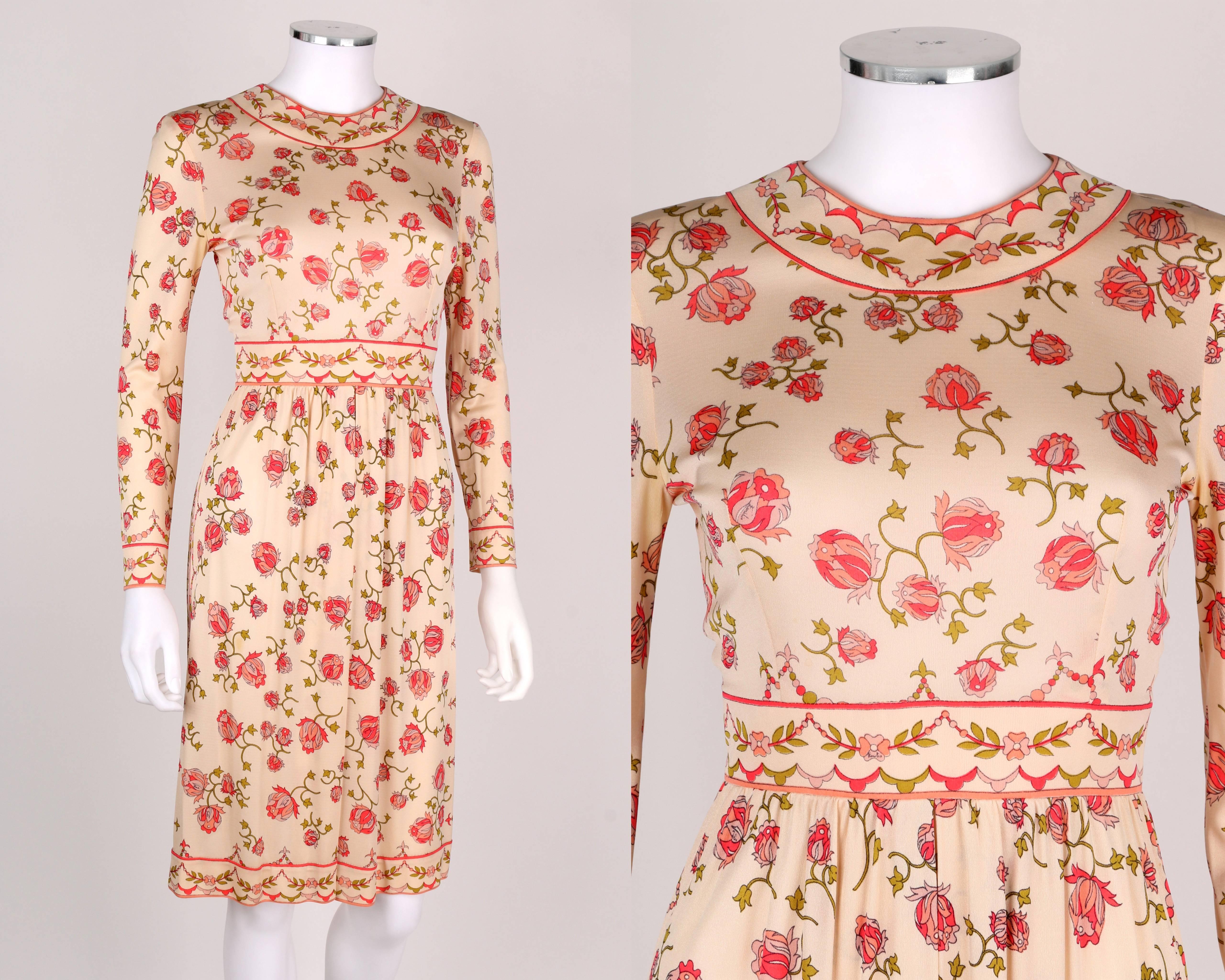 Vintage 1970’s Emilio Pucci rose signature print cream, pink and green silk jersey dress. Long sleeves. Round neckline. Yoked waist. Gathered skirt with center pleat detail. Decorative border at collar, waist and hemline. Center back zipper and