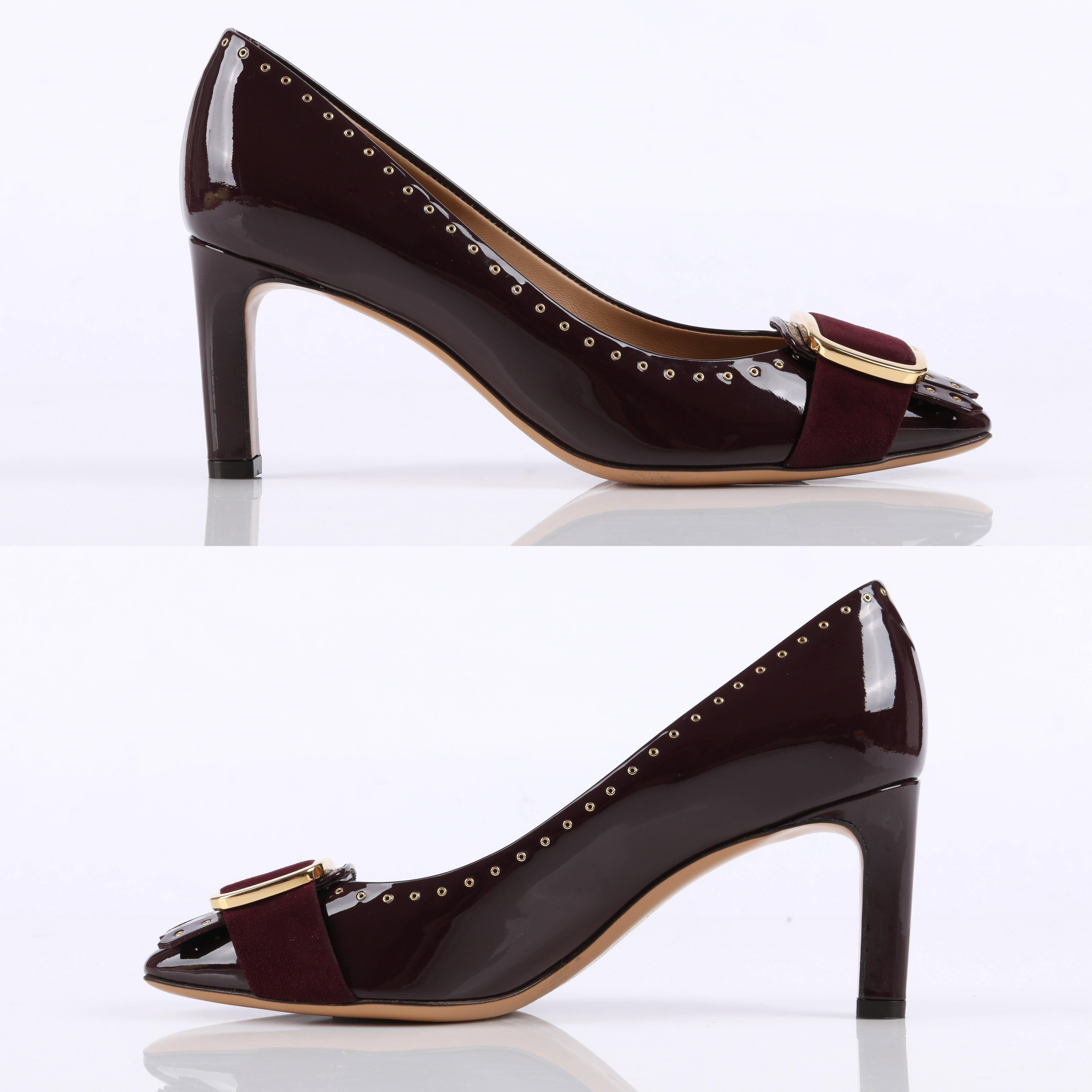 Salvatore Ferragamo burgundy patent leather pumps. Large gold buckle and suede strap with fringe detail on toe. Small gold grommets embellishment around edges and fringe. Slip on. Fully lined in leather. Top, lining, and sole all constructed of
