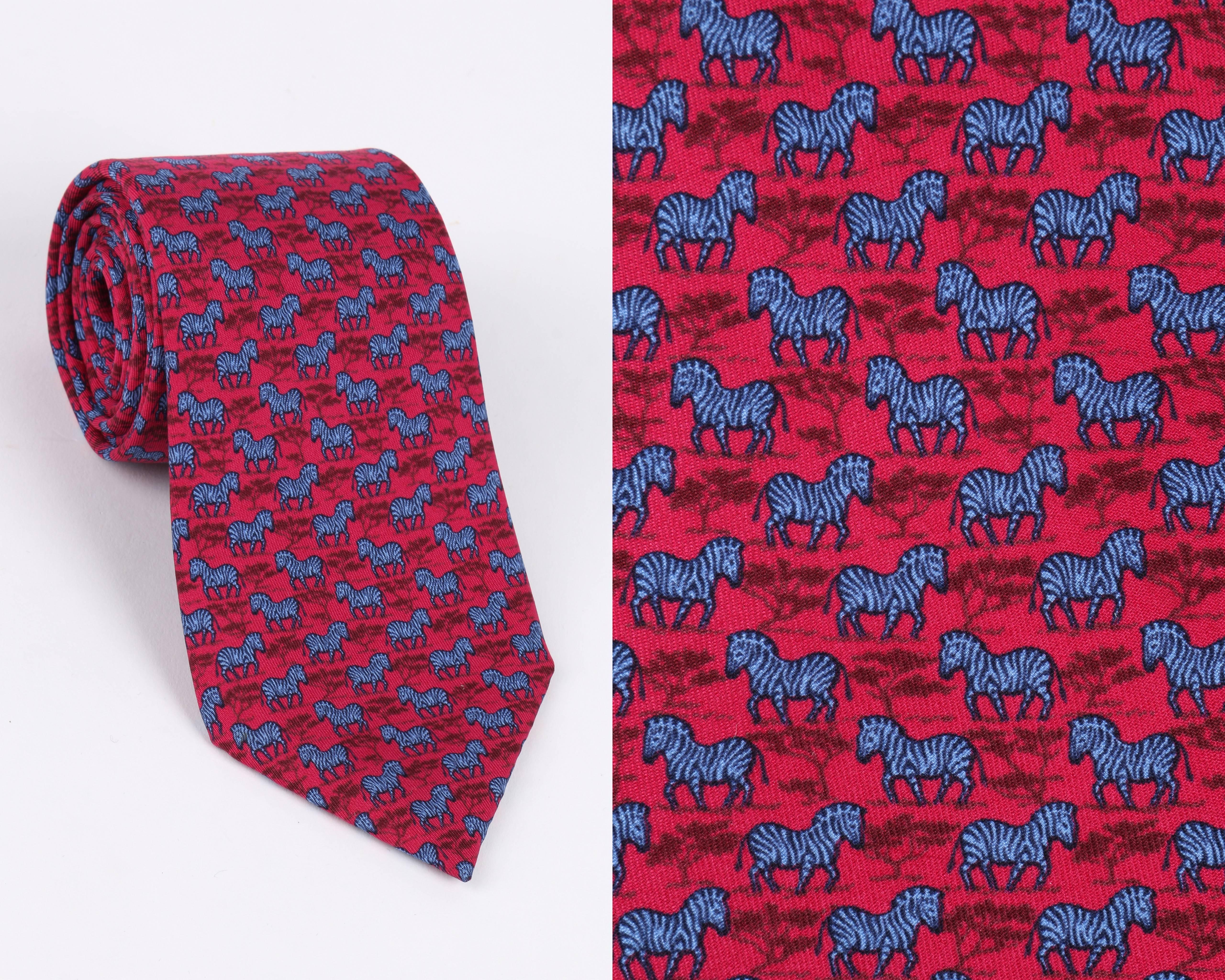 Hermes raspberry and blue neck tie with zebra and tree print. Hermes logo printed on neck tie tail. 5 fold. Serial number 7110 OA. Marked fabric content: 