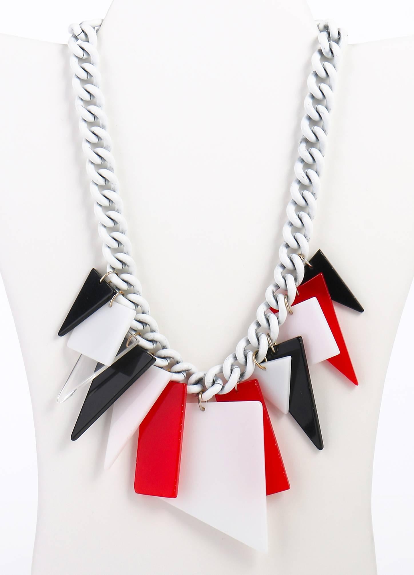 One of a kind vintage c.1960's Mod red, white, clear and black large acrylic/lucite geometric shaped dangles chain necklace. Dangles attached to white enamel coated metal large link chain. The 13 various geometric shaped dangles range from