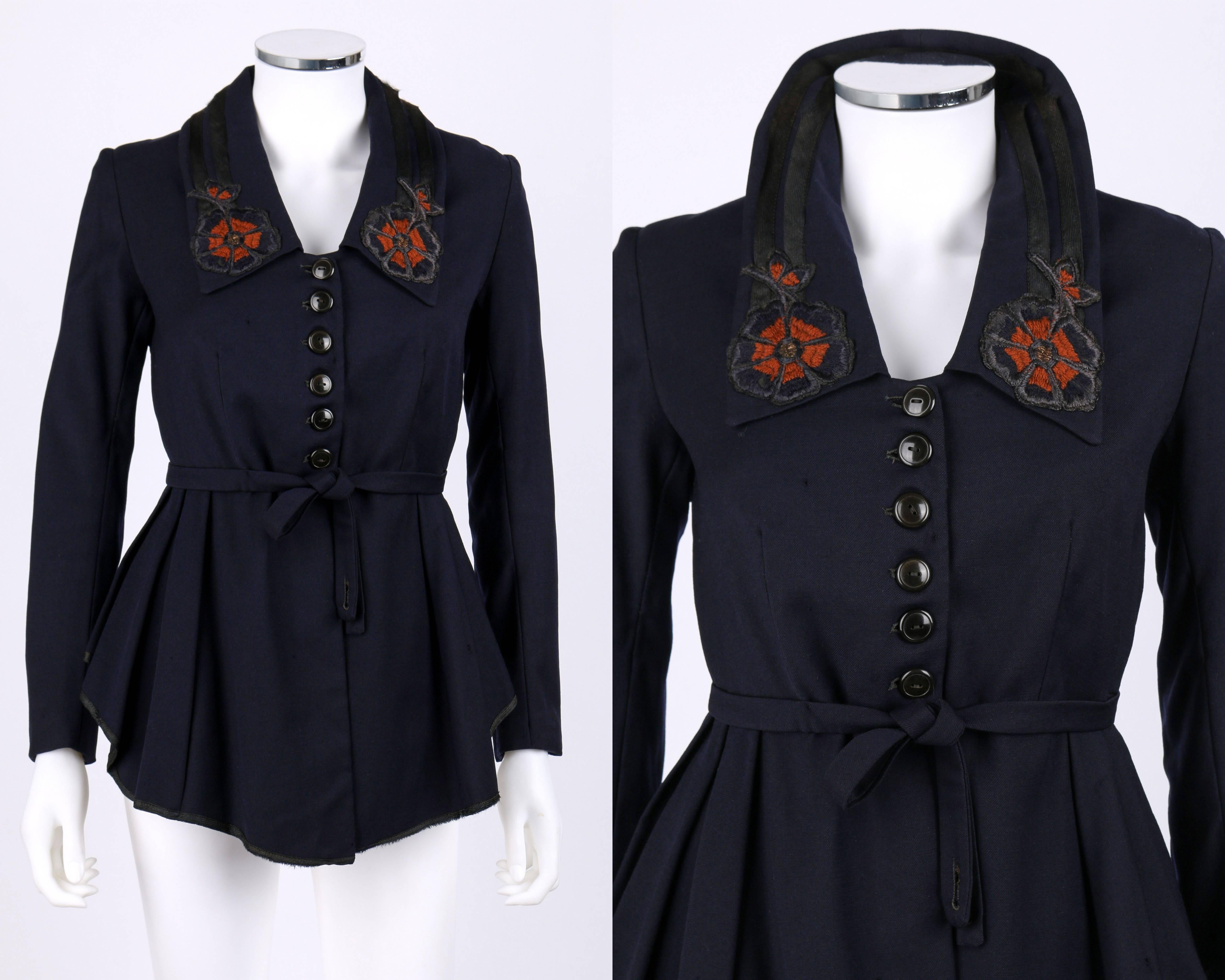 Vintage couture c.1910's navy blue wool jacket. Navy and orange floral embroidery at collar and back. Pleated peplum with attached belt at waist. Long sleeves with button detail at cuffs. Jacket buttons at center front. Printed silk lining. Unmarked