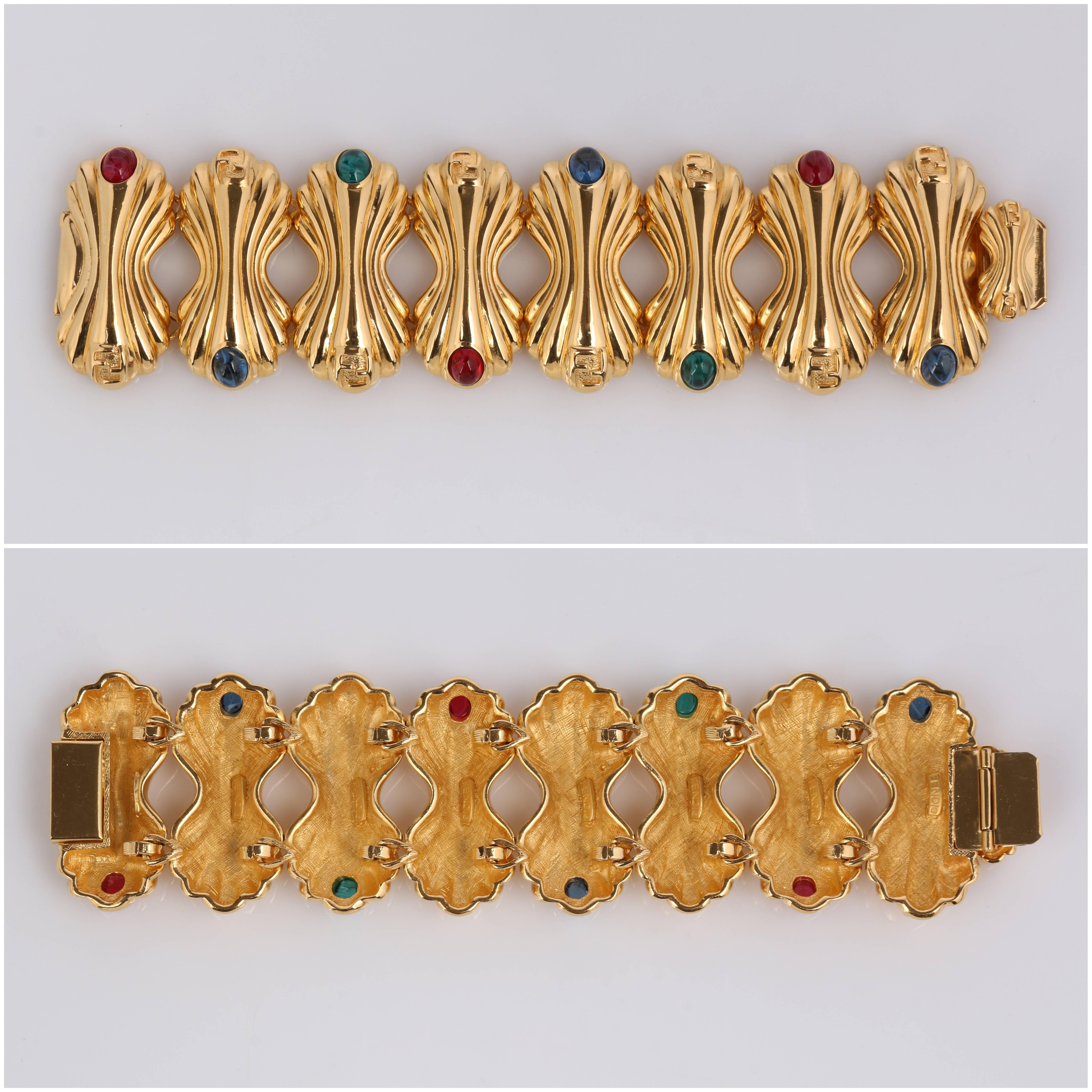 Vintage c.1980's Fendi gold tone statement chunky bracelet and earring set.  Bracelet has large gold tone bow tie shaped links with grooved detail, one end marked with FF Logo and the other end with alternating sapphire blue, pink, and emerald green