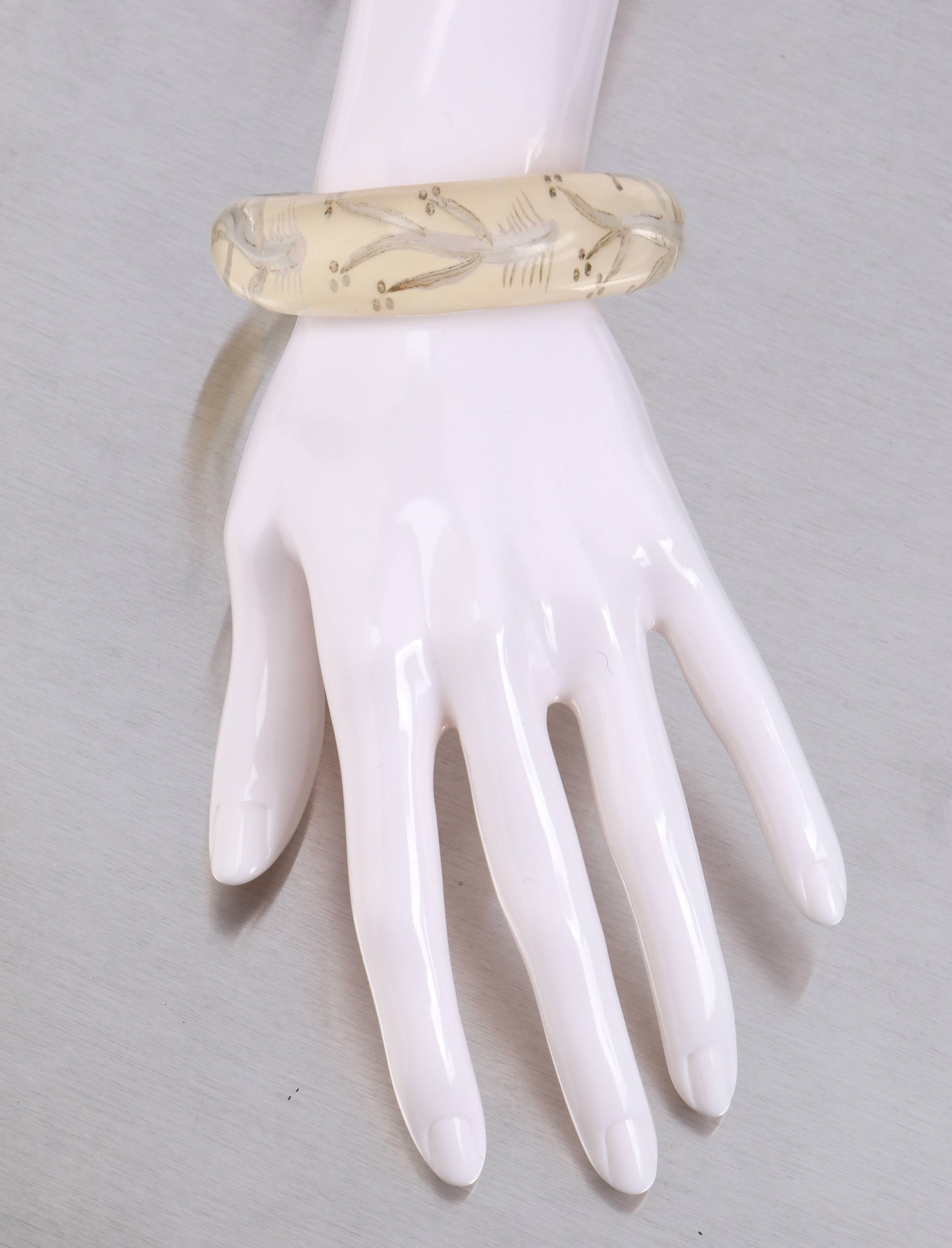 Extremely rare vintage c.late 1930's - early 1940's clear plastic with ivory color back etched fish bone design bypass bangle bracelet. Reversed hand carved horizontal fish bone pattern repeated around bracelet. Back of bracelet is a soft