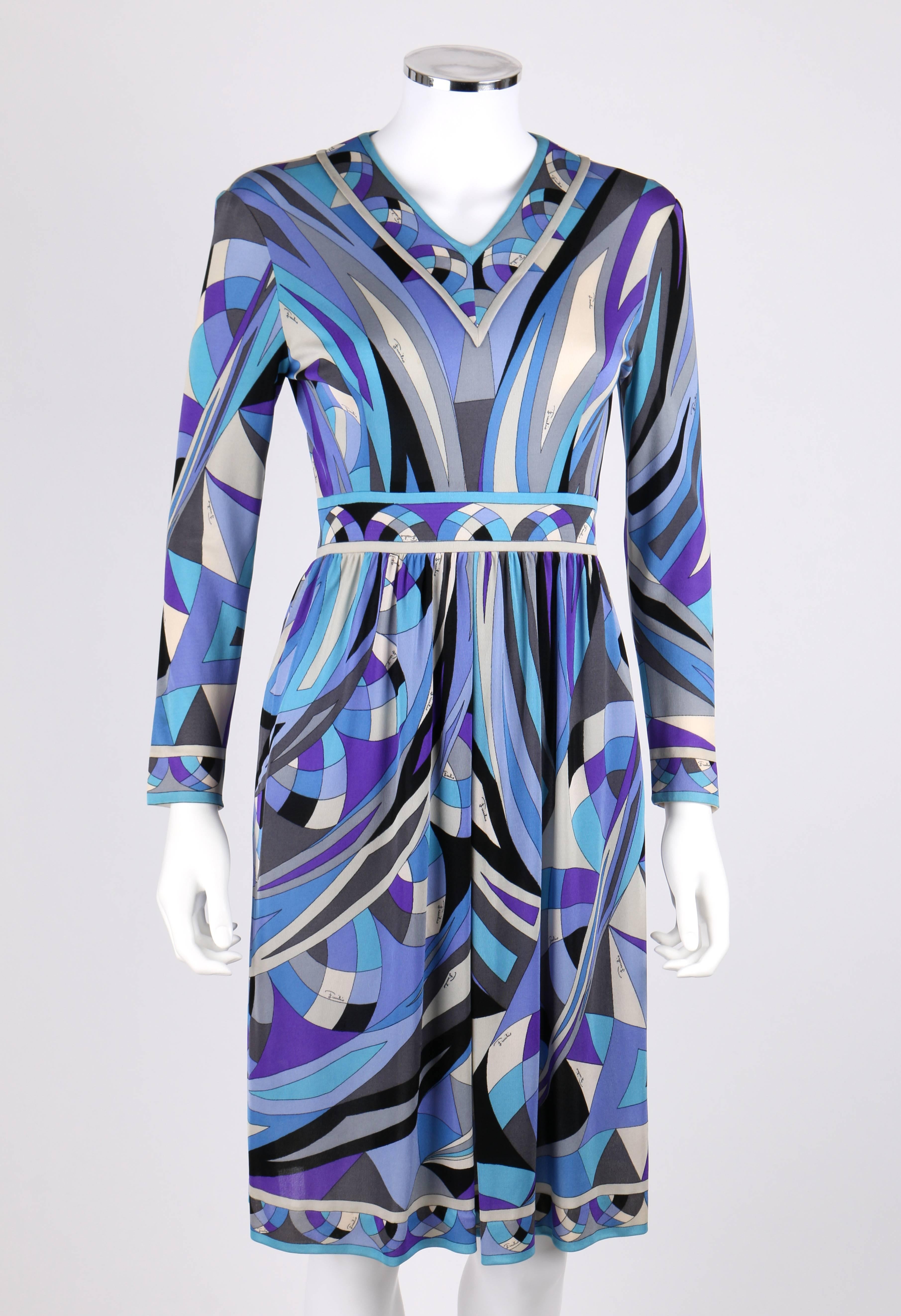 Vintage c.1960's Emilio Pucci signature print in shades of blue, gray, and cream silk jersey dress. Long sleeves. V-neckline. Yoked waist. Gathered skirt with center pleat detail. Decorative border at collar, waist, hemline, cuffs, and zipper.