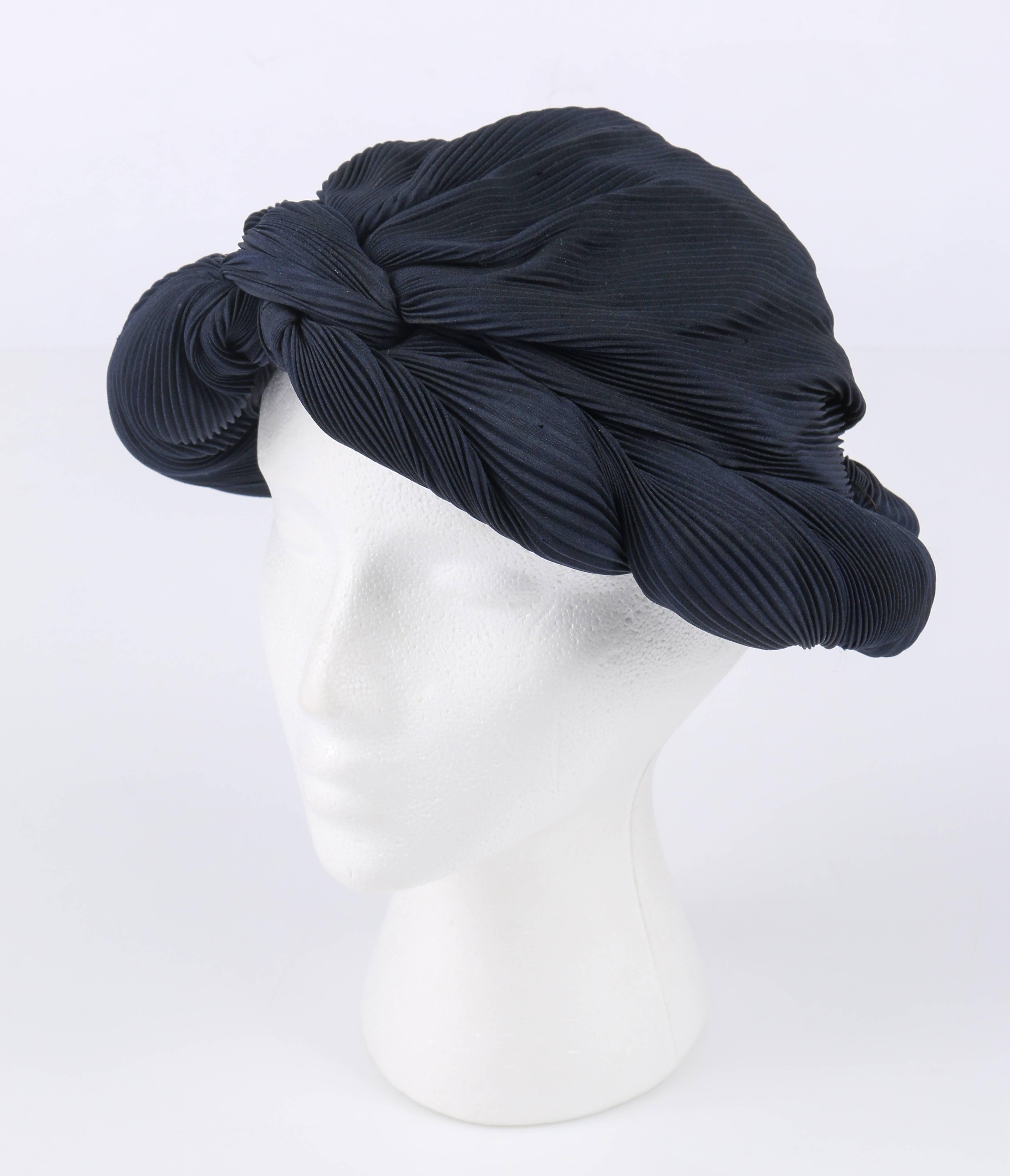 Vintage c.1930's Mitternacht marineblau / schwarz plissiert Seide Turban Stil Abendessen Hut. Körper aus plissierter Seide. Die Krempe mit gedrehten Falten wird an der Stirn geknotet. Mit schwarzer Seide gefüttert und mit Grosgrain-Band eingefasst.