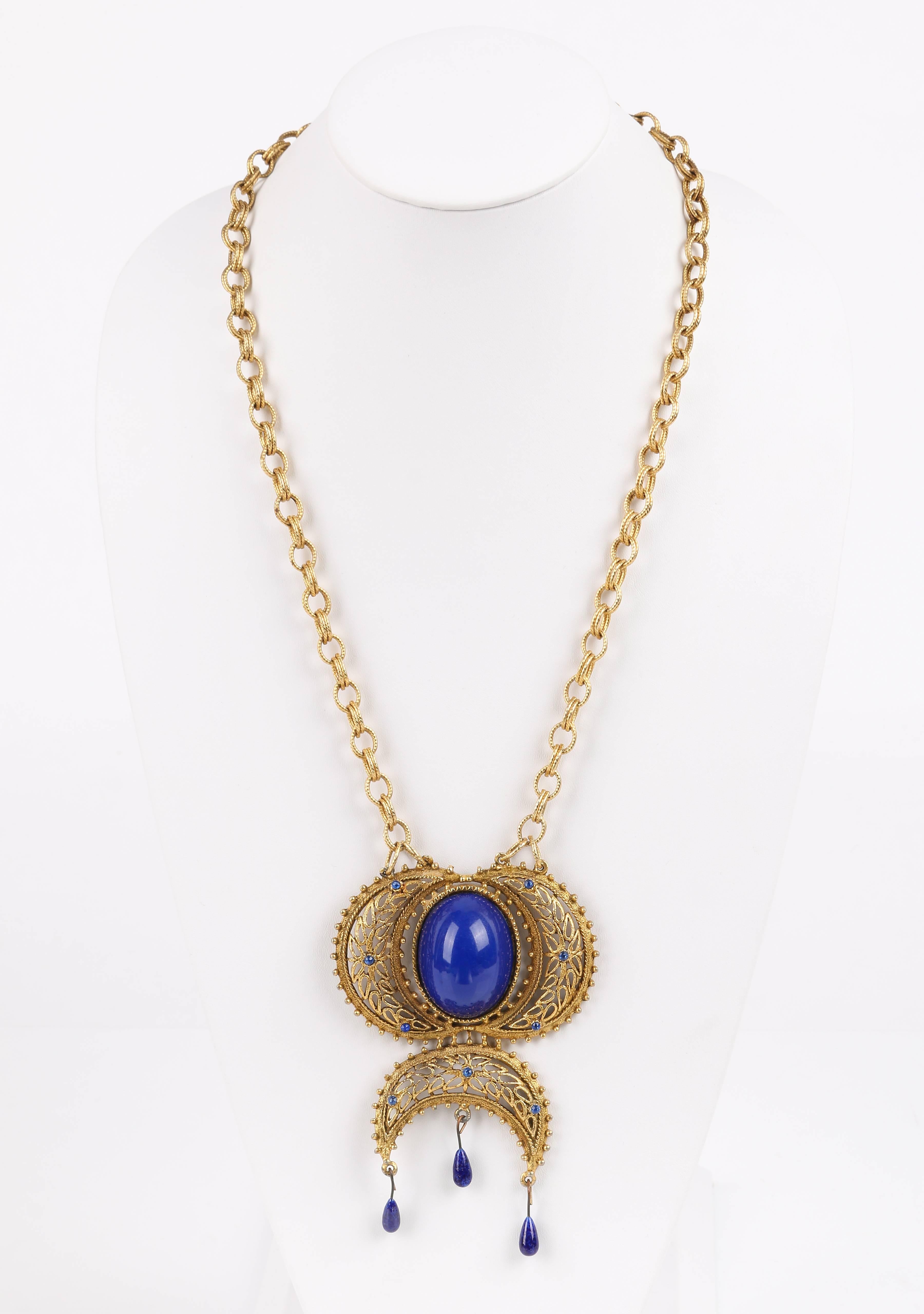 Vintage c.1980's one of a kind Napier pendant and D&E Juliana chain jewelry artisan created Egyptian revival statement necklace. Large statement pendant has three gold tone open work metal crescents surrounding a large blue colored cabochon domed