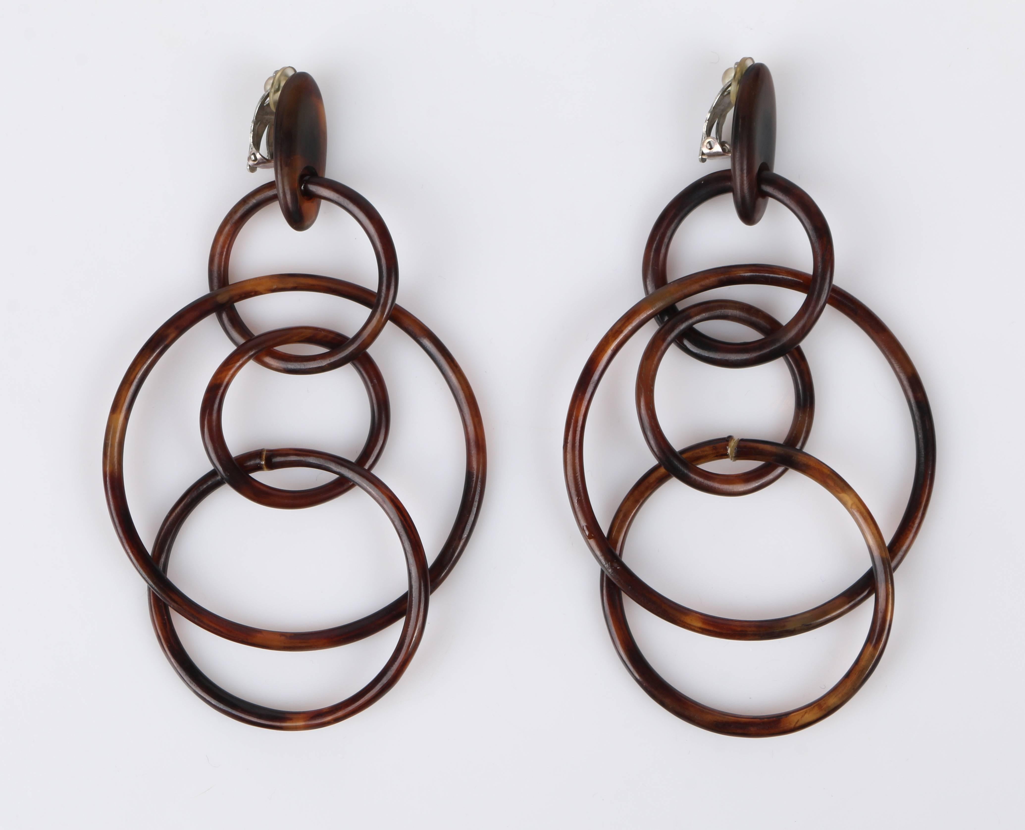 Vintage c.1970's Monies huge statement multi-hoop linked clip on earrings. Multi-hoop linked earrings appear to be made of brown horn/resin material with a tortoise shell pattern. Four hoops are linked to form 3 dimensional dangles.  Hoop dangles