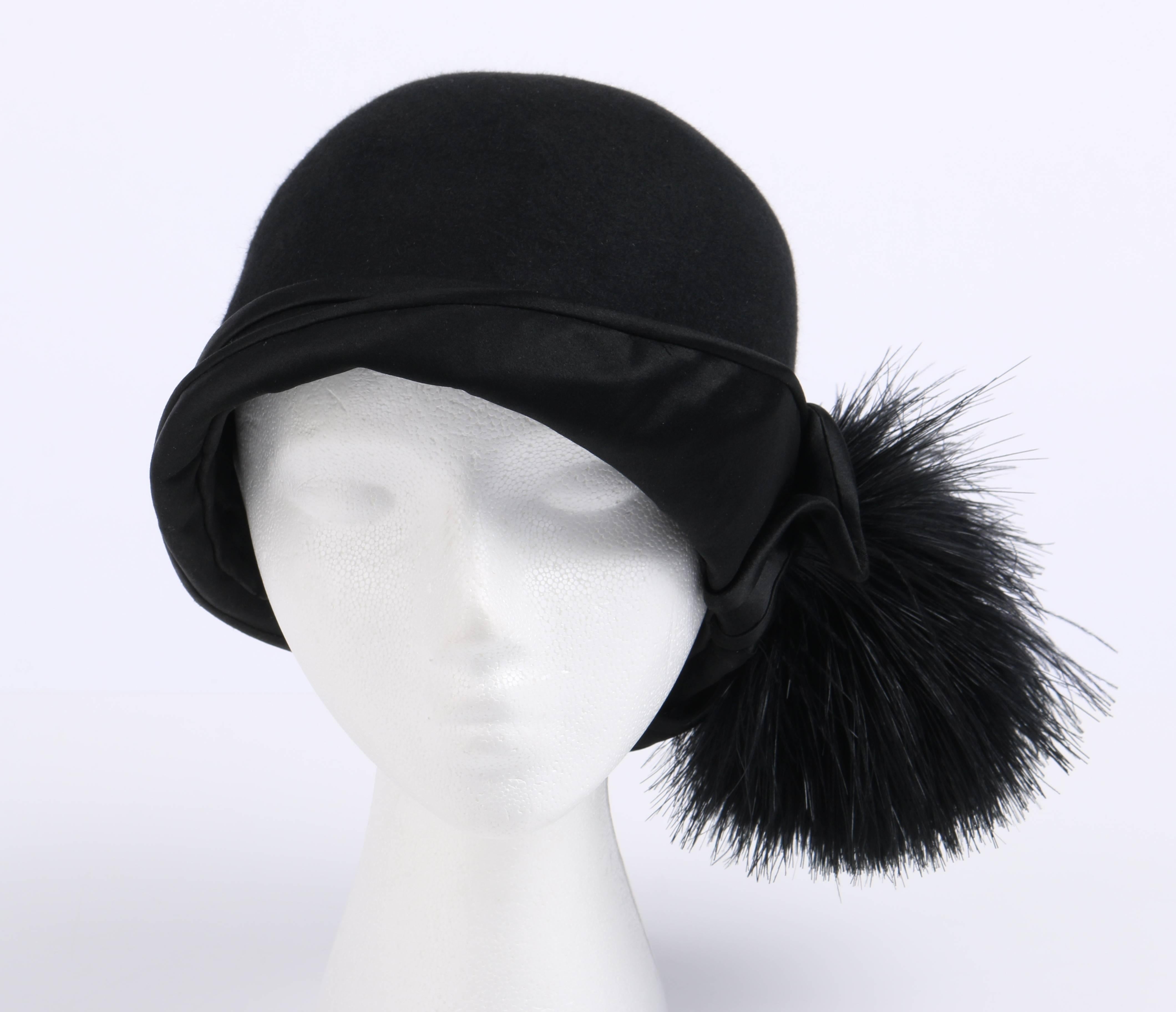 Vintage c.1920's BelArt (DH Co.) black wool / beaver felt flapper cloche hat. Bell shaped body. Turned up black satin asymmetrical brim. Large black feather pom pom embellishment attached to side of brim. Black silk lining. Unmarked Fabric Content:
