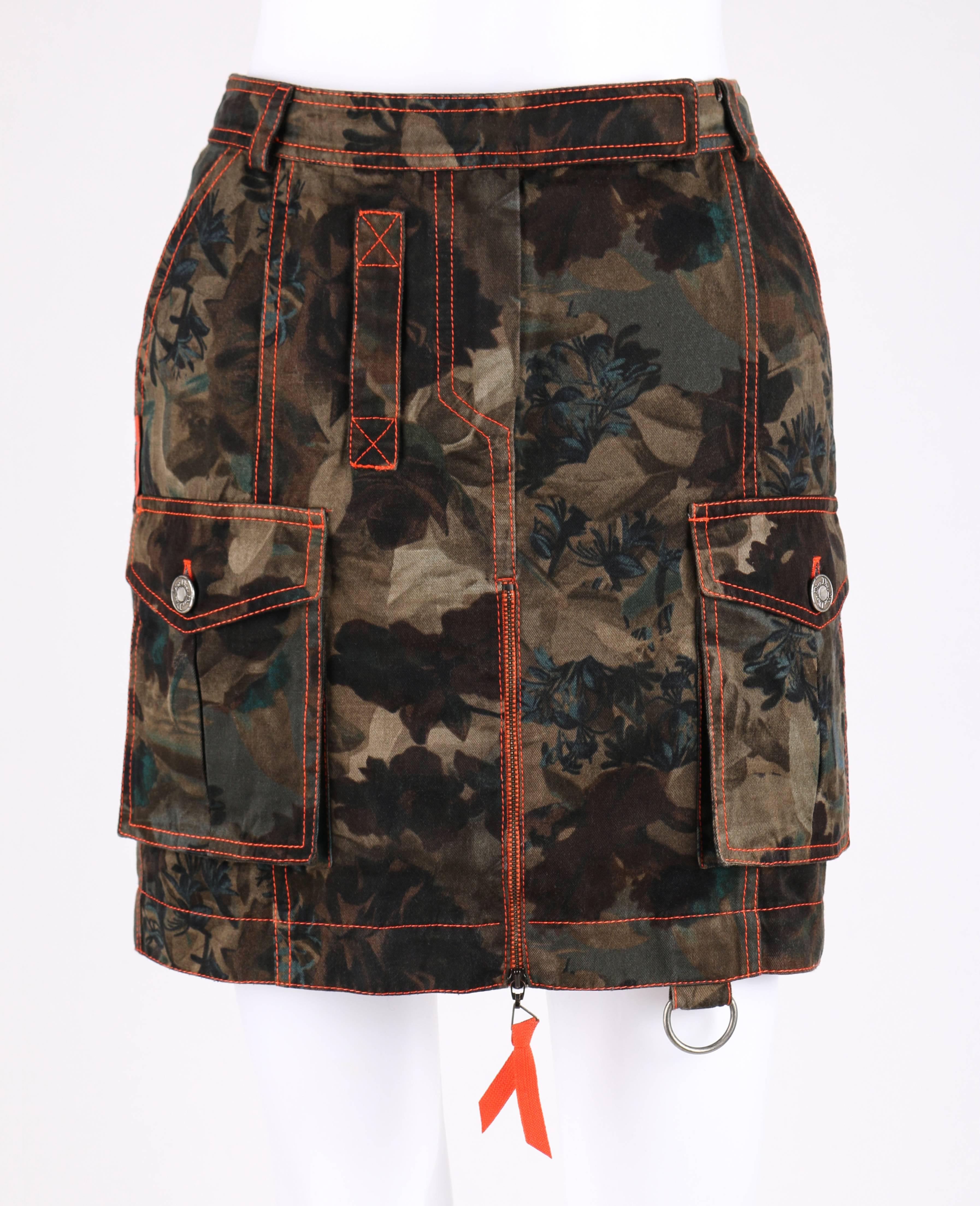 Christian Dior S/S 2001 hidden dark floral camouflage military inspired cotton denim print cargo skirt. Designed by John Galliano. Center front exposed metal zipper closure with orange zipper pull. Two front inverted pleat bellow pockets with flap
