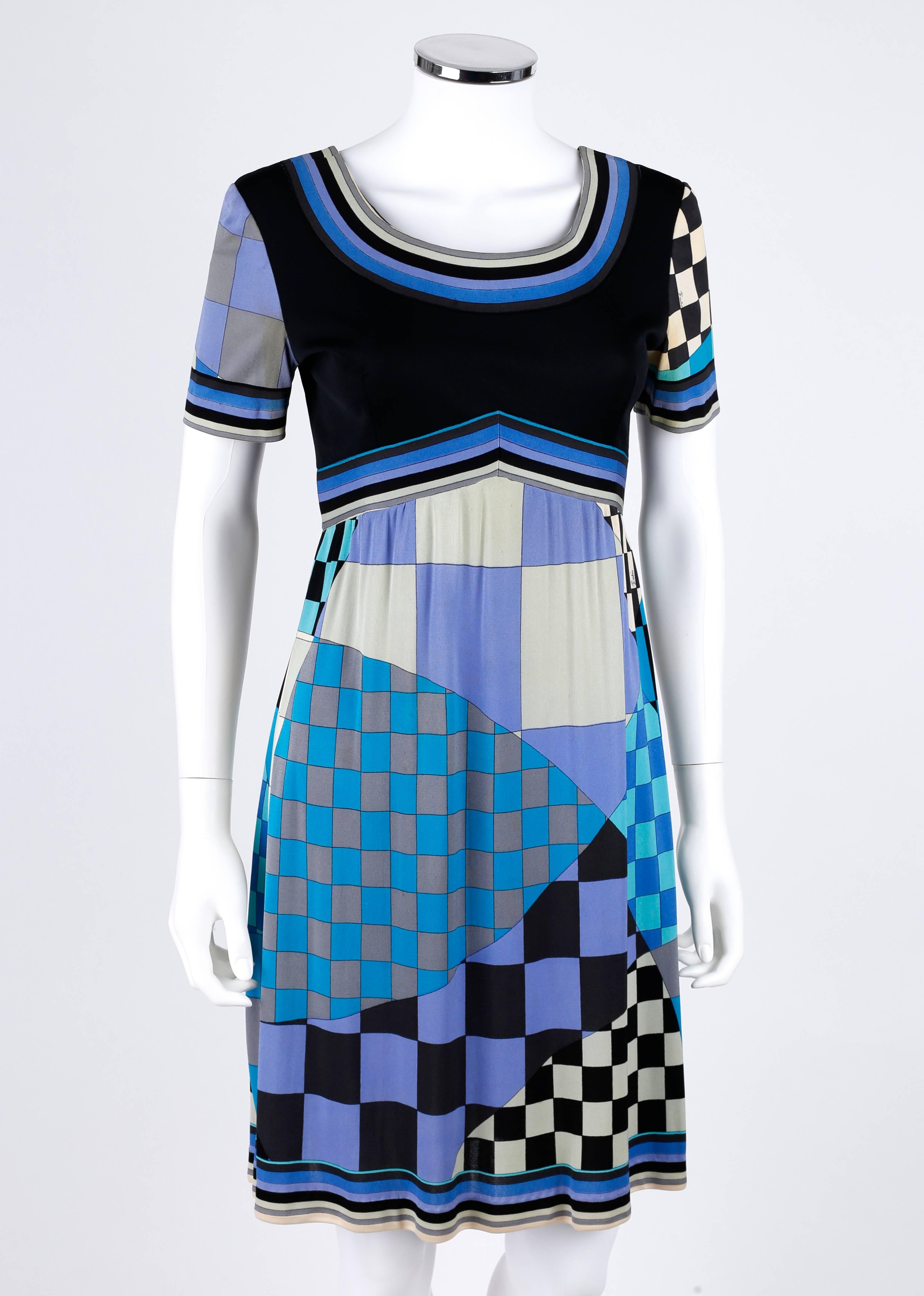 Vintage c.1960's Emilio Pucci for Saks Fifth Avenue silk jersey dress. Black bodice with short sleeves. Checkerboard signature print skirt and striped boarder trim in shades of blue, black, and gray. Empire waistline. Low scoop neckline. Side seam