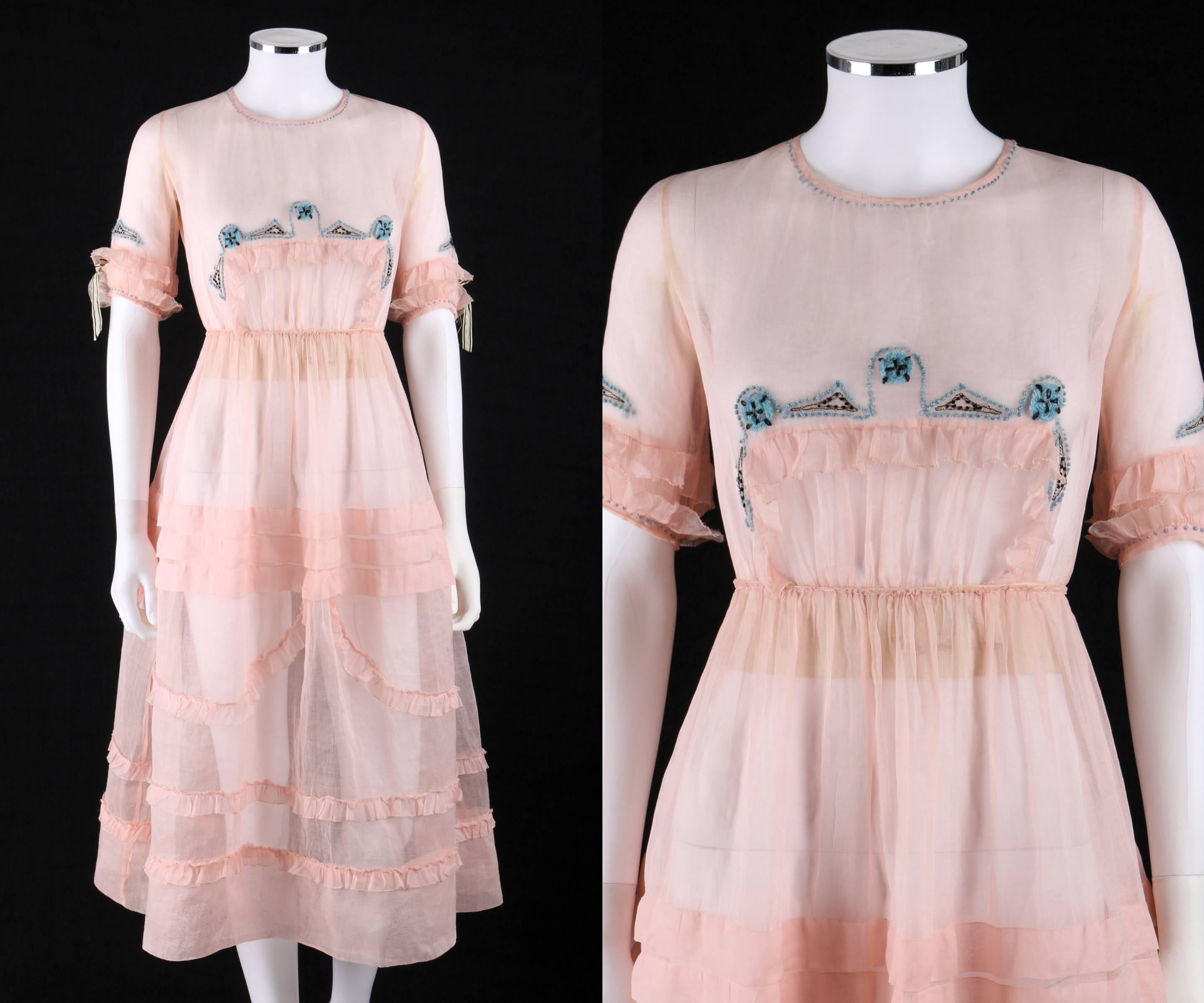 One of a Kind - Late 1910's Couture pink silk organza sheer day dress. Blue and black geometric yarn embroidered detail at collar, cuffs, and center front. Jewel neckline. Elbow length sleeves with tiered ruffles and silk bow detail at cuffs.