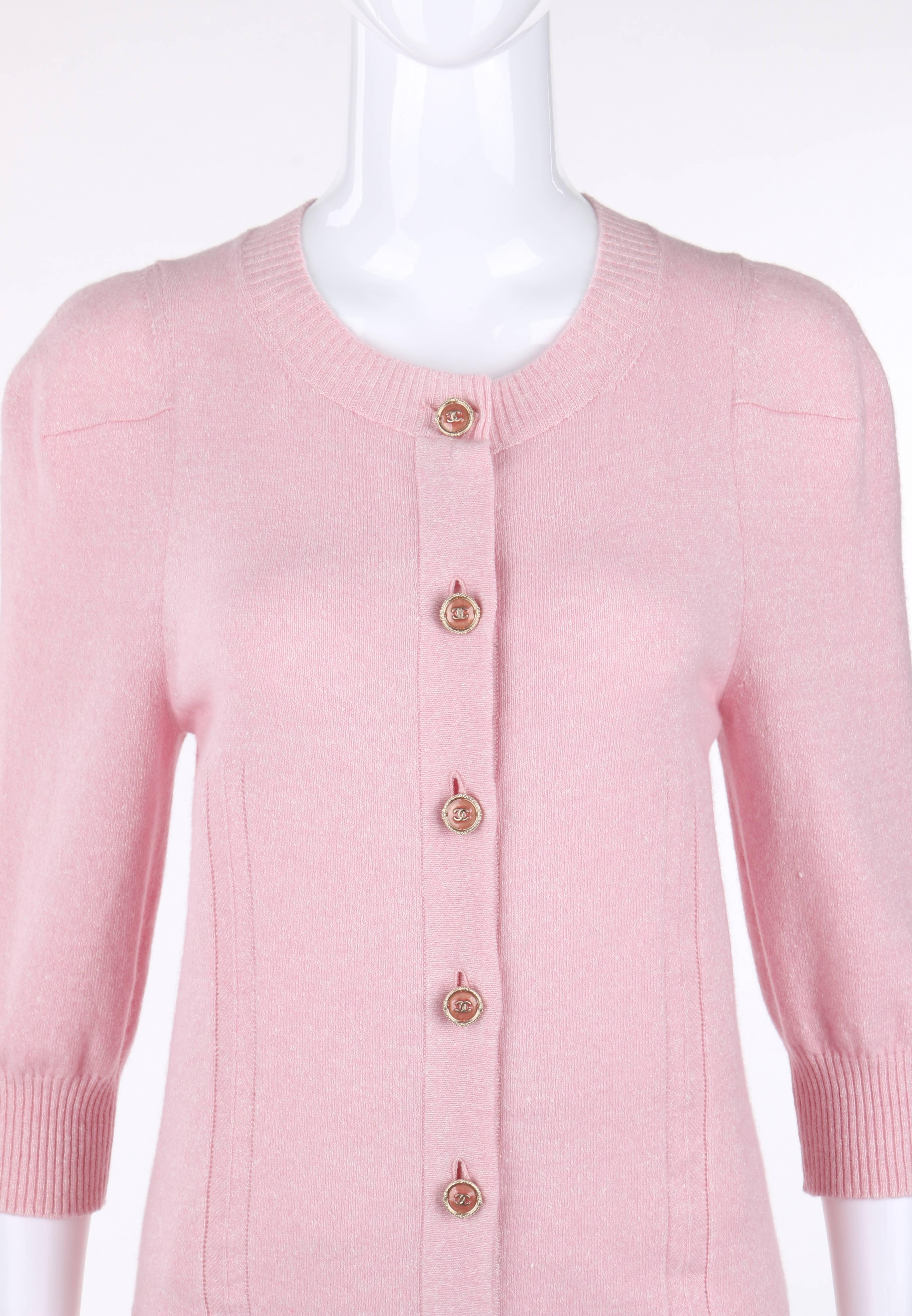Chanel Resort 2013 pink linen & cashmere blend cardigan knit sweater. Pink and white heathered knit. Scoop neckline. Seven center front pink and gold-toned CC button closures. Front and back herringbone single stripe detail. 3/4 length sleeves. Rib