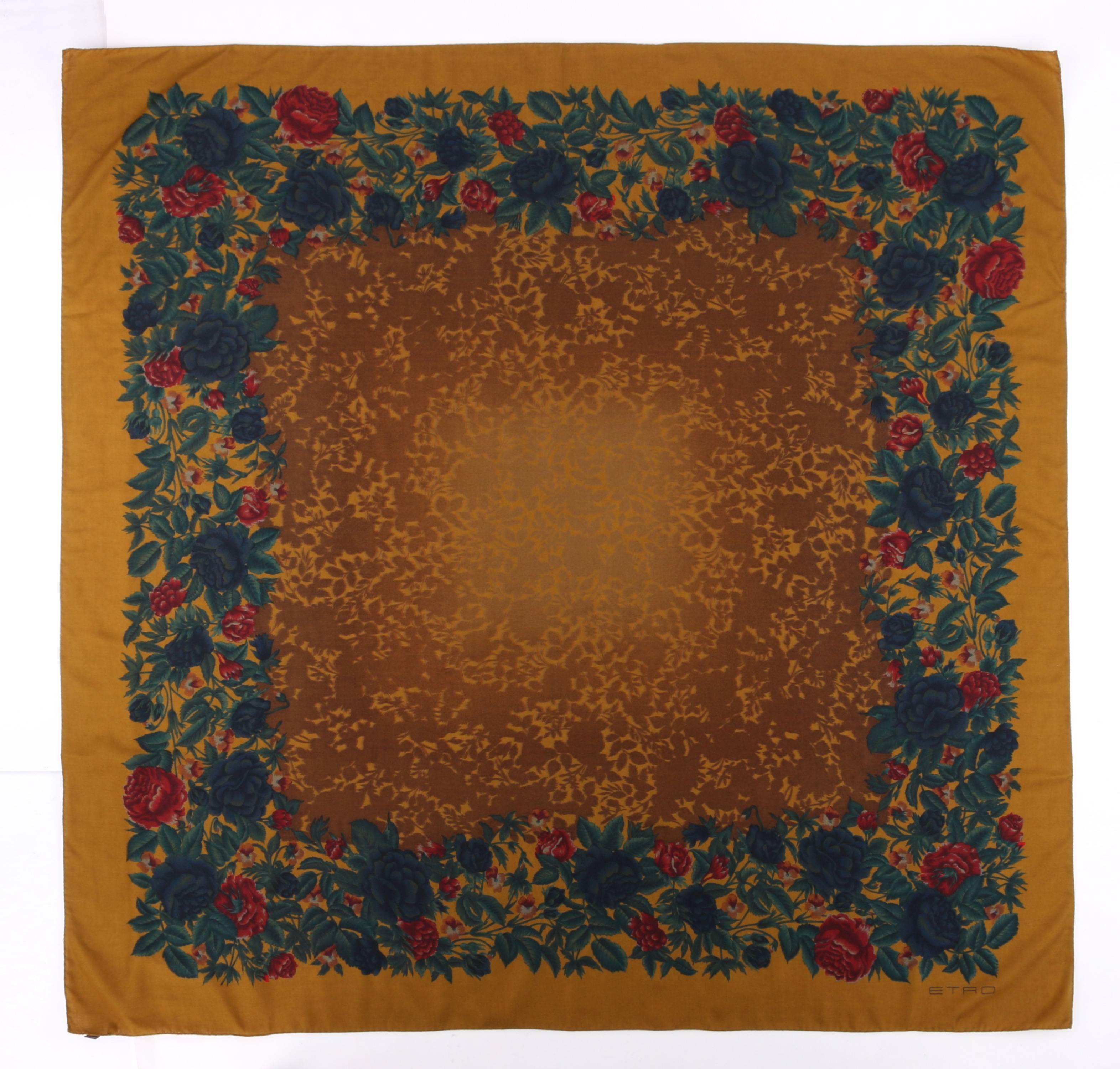 Etro gold multicolor floral print large wool silk scarf. Foral motif boarder in shades of green, blue, red, and yellow. Silhouetted floral print with ombre fade to center. "ETRO" printed bottom right corner. Hand rolled edges. Marked