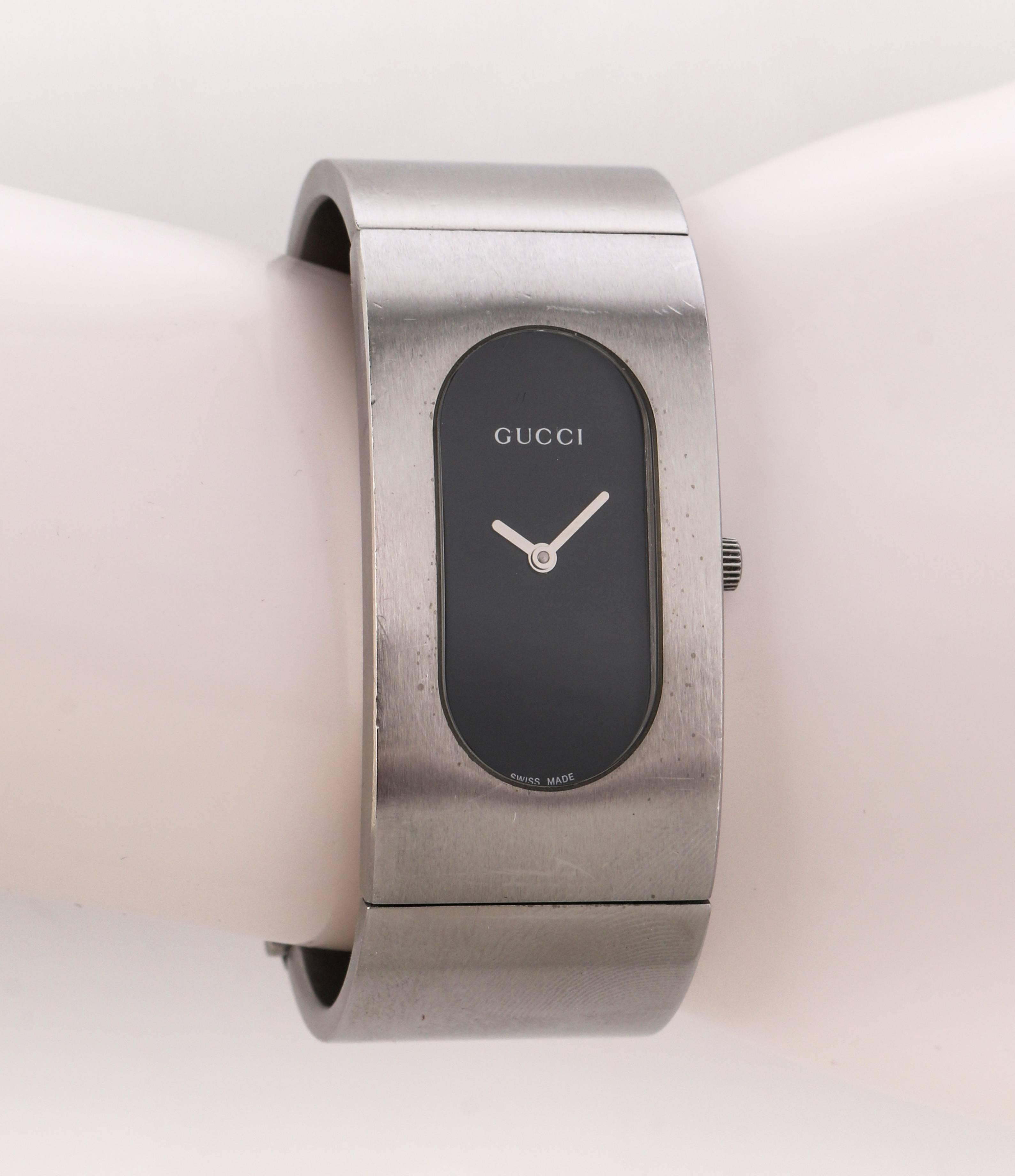 Gucci 2400L black oval dial stainless steel ladies bangle bracelet watch. Black oval dial set in stainless steel bracelet / bangle. Analog style without numbers. Silver-toned hands. 