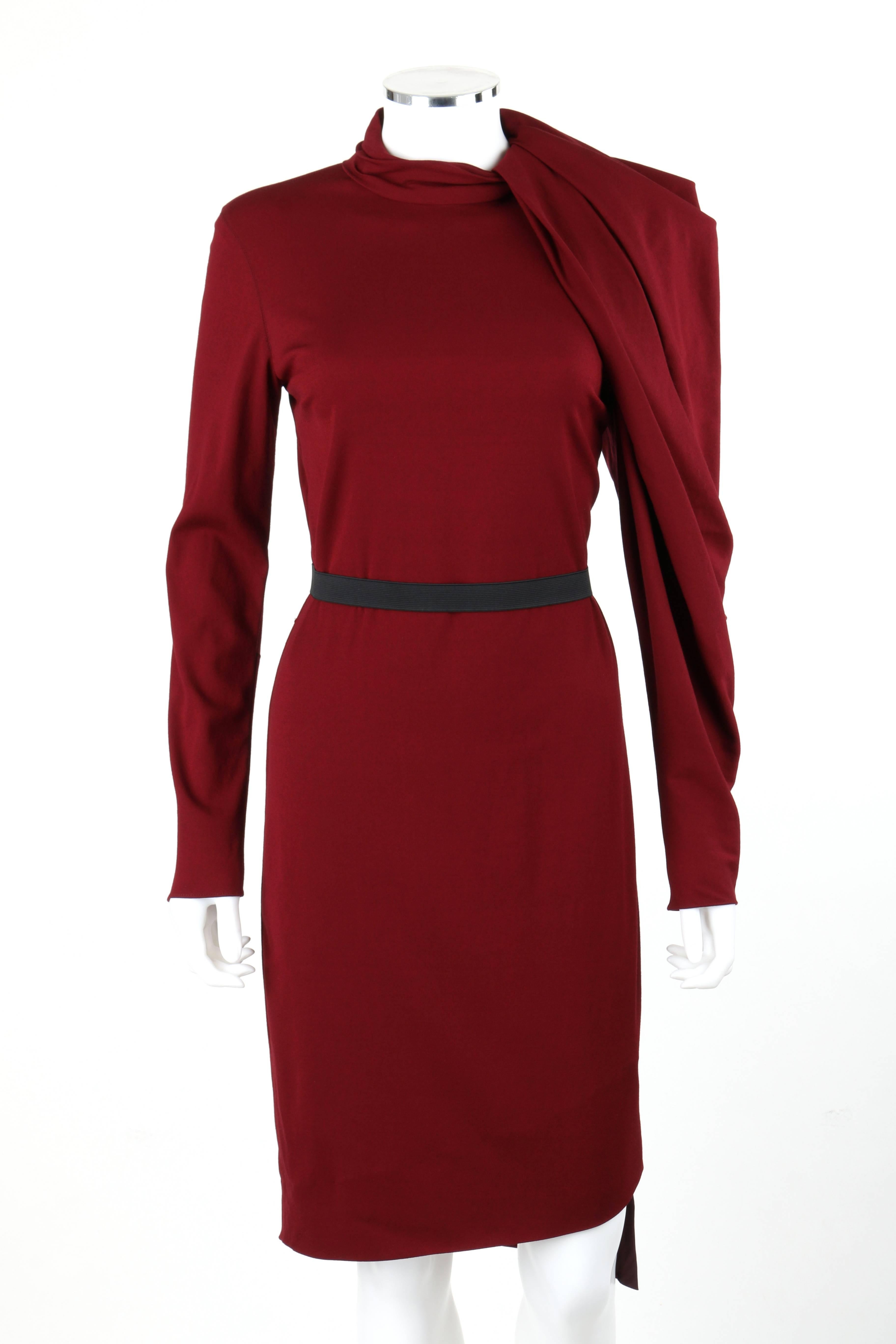 Lanvin Autumn/Winter 2011 burgundy red wool asymmetrical draped sleeve cocktail dress. Designed by Alber Elbaz. Mandarin collar with box pleat detail. Left asymmetrical long sleeve with box pleat and draped detail which wraps from left side of