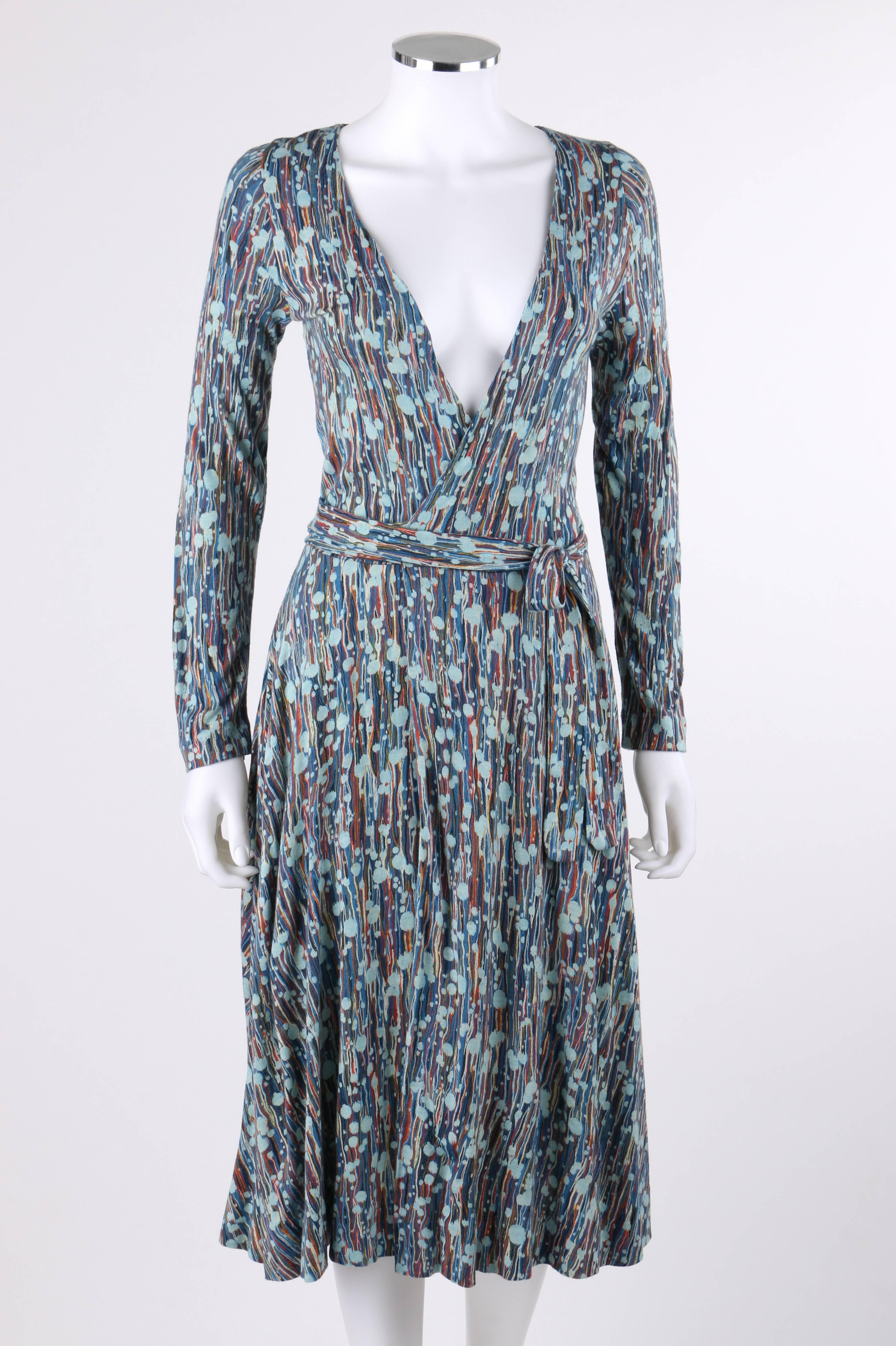 Vintage Diane Von Furstenberg DVF c.1970's multi-color painterly print jersey knit iconic wrap dress. Abstract painterly print in shades of orange, yellow, black, blue, and white. Deep v-neckline. Long sleeves. Two attached fabric ties at waist.