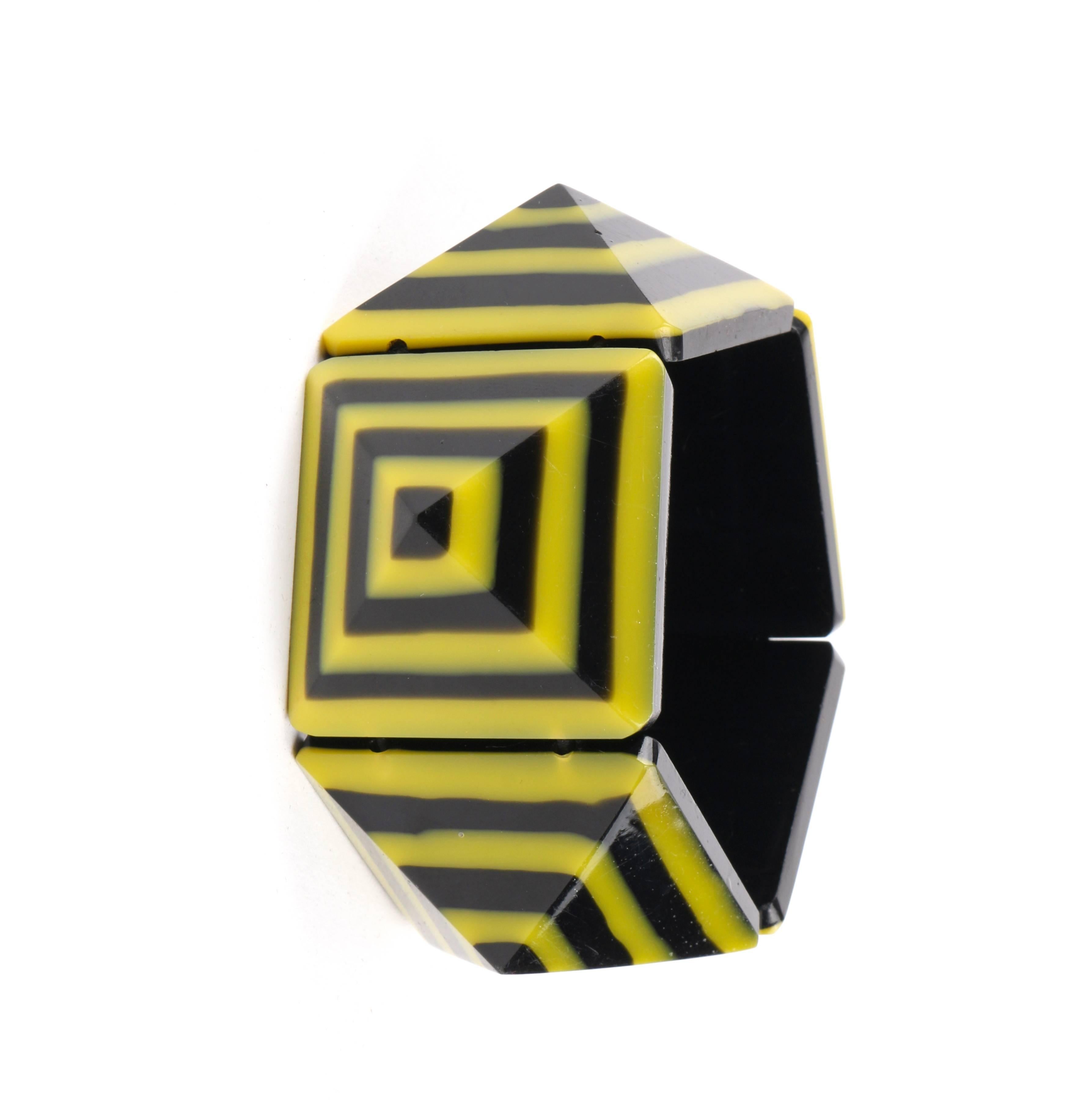 Vintage c.1980's black and yellow Lucite plastic pyramid geometric stretch bracelet. Five black and yellow layered Lucite pyramid shaped beads. Each bead is thread onto two rows of black elastic cord for a slip on style. Piece is unmarked.