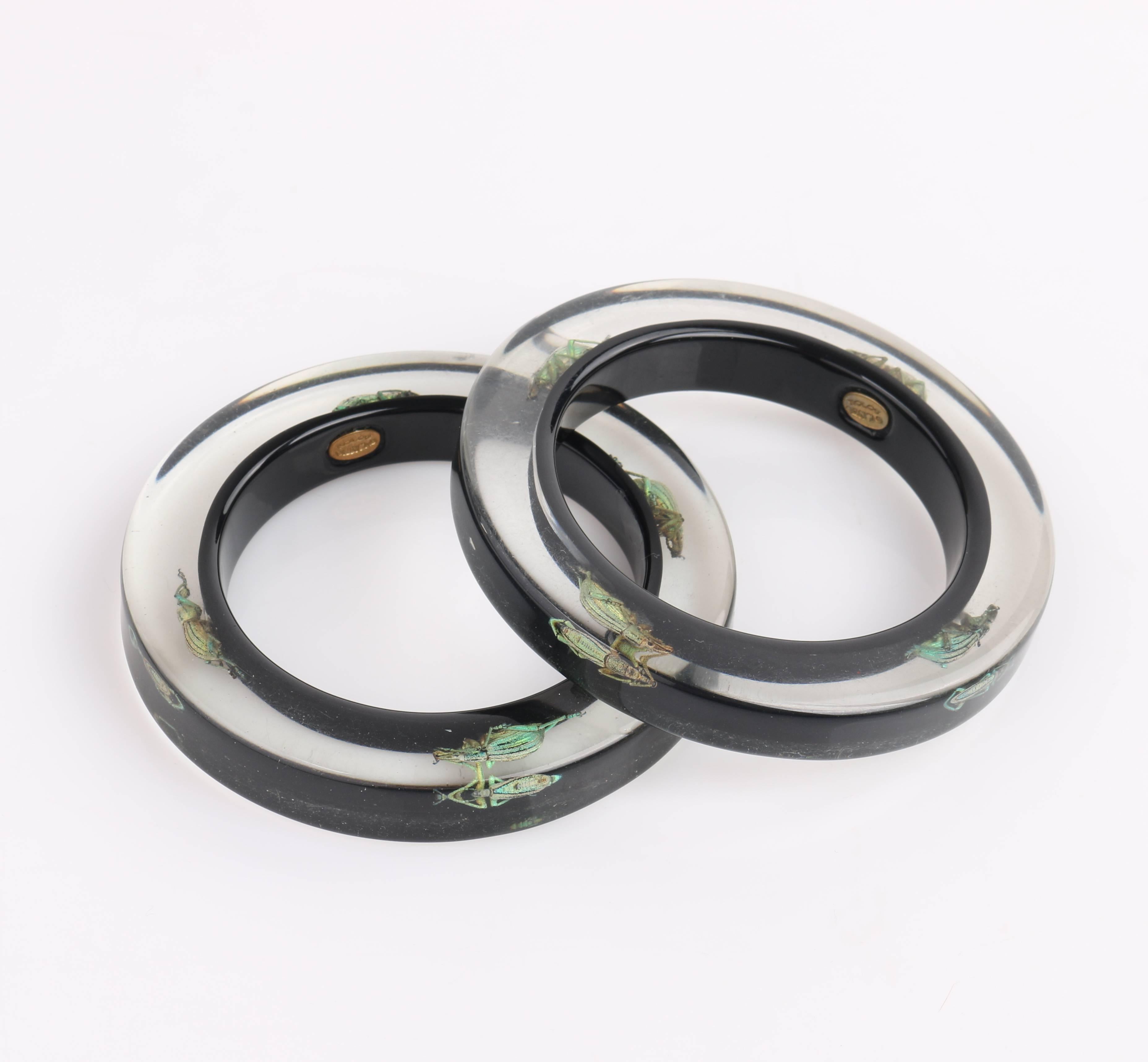 Kolos Designs two piece black translucent lucite beetle bangle bracelet set designed by Mikhail Bereslavski. Four green iridescent exotic beetles embedded in clear lucite. Solid black lucite at back of bracelet. Slip-on style. Gold-toned oval