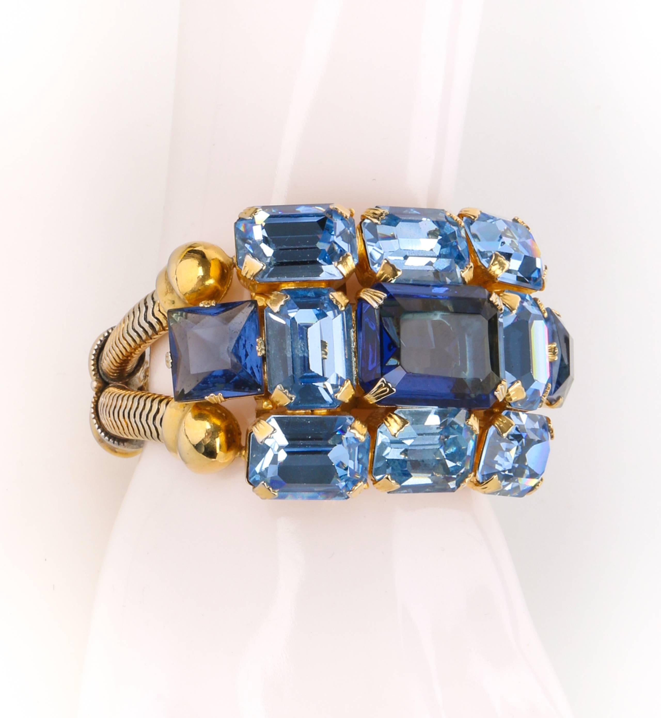 Vintage unsigned c.1950's blue glass rhinestone double banded statement bracelet. Eight prong set sky blue octagon rhinestones with two square sapphire rhinestones on either side surrounding one large sapphire blue octagon rhinestone at center.