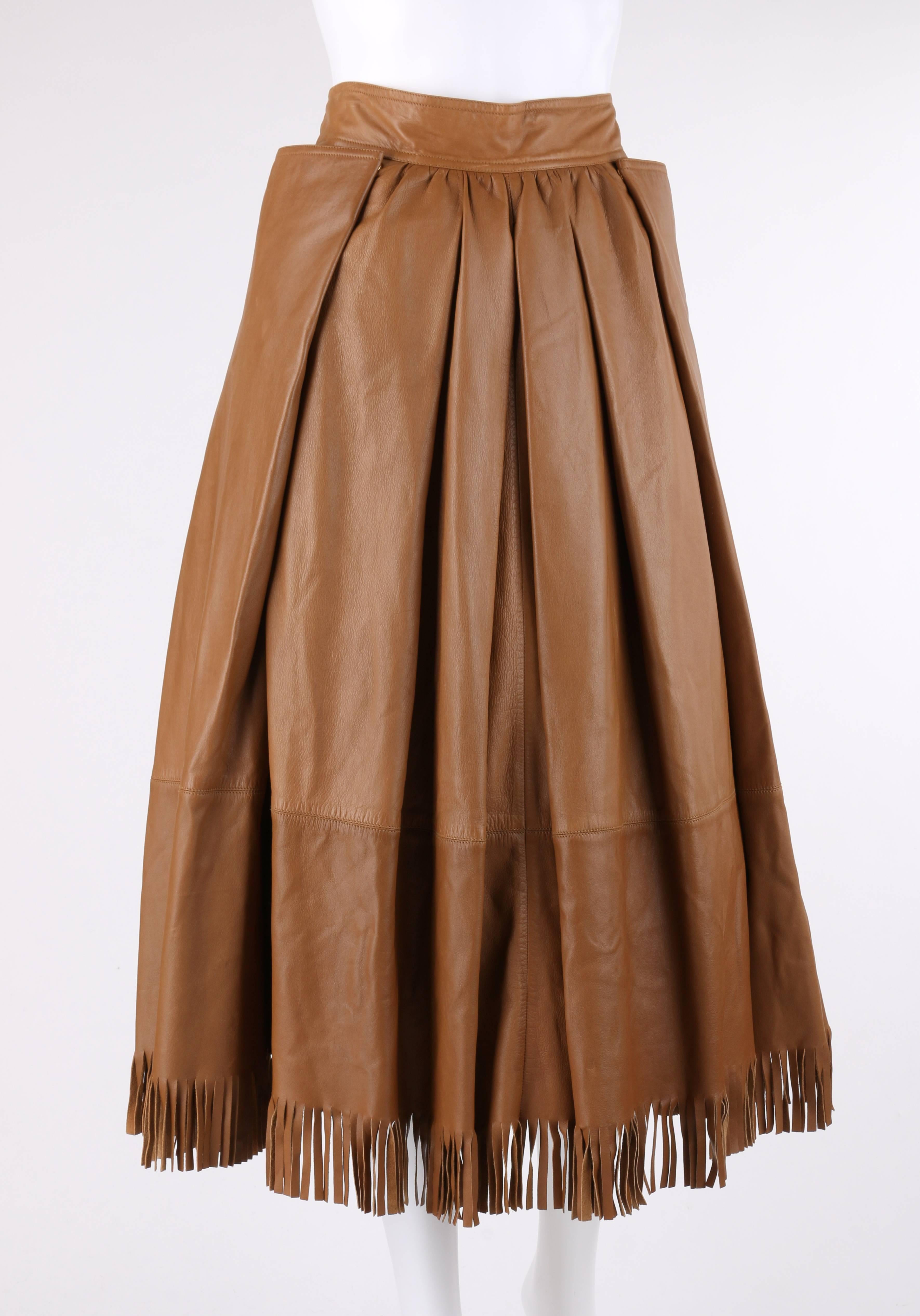 Vintage Gucci c.1970's tan brown leather pleated tea length skirt. Thin banded waist. Four front and back knife pleats. Lightly gathered waist. Pleated side seam panels with single snap closure at front and back and pocket. Gold-toned signature 