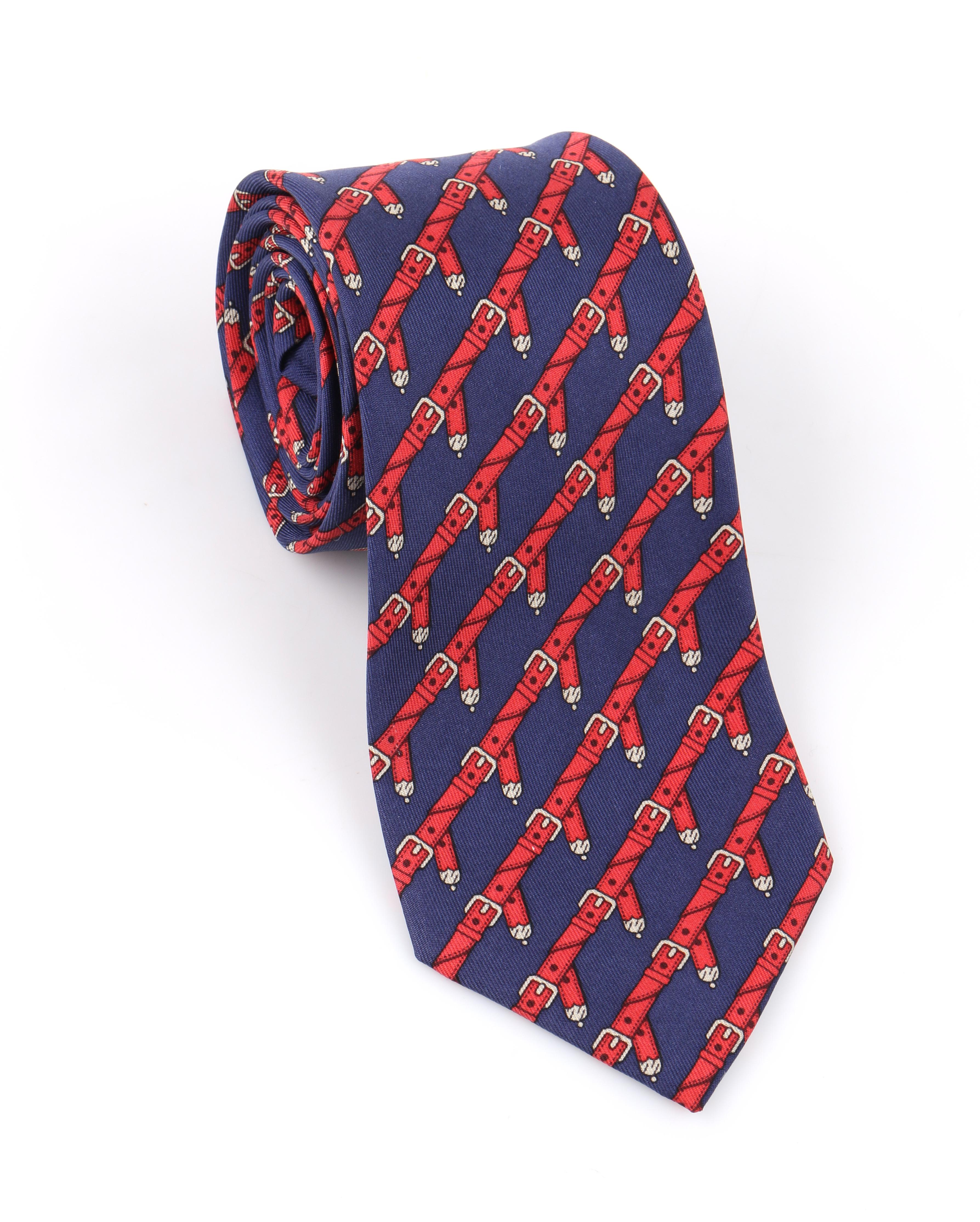 DESCRIPTION: HERMES c.1980's Navy Blue & Red Equestrian Belt 5 Fold Silk Necktie Tie 954 IA
 
Circa: c.1980’s
Label(s): Hermes; Neiman Marcus
Designer:
Style: 5 fold necktie
Color(s): Navy blue, red, gray
Lined: Yes
Marked Fabric Content: 100%