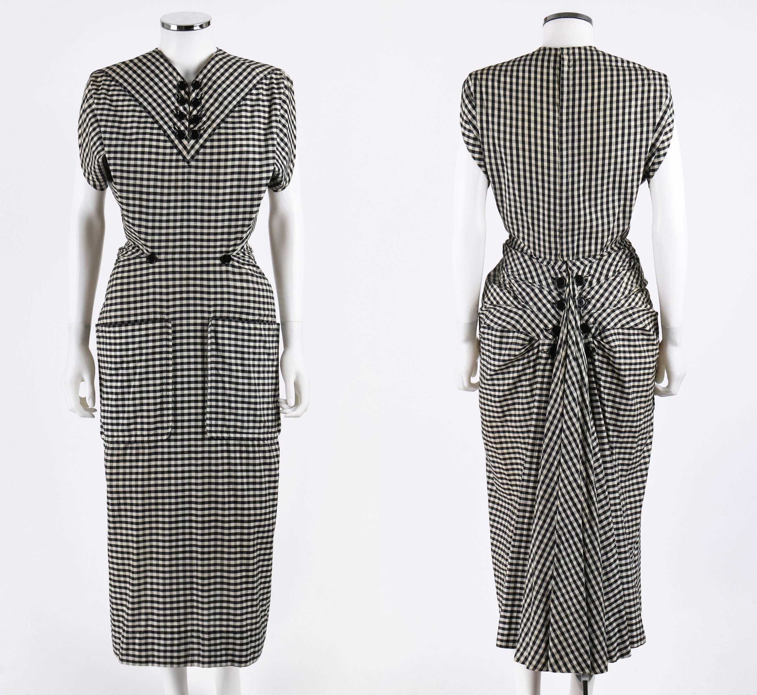 Incredibly rare Jacques Fath black and white cotton gingham dress from his Spring-Summer 1949 American collection for Joseph Halpert. Impeccably tailored fan-tail bustle back with peplum flair is embellished with buttons. Two large front patch