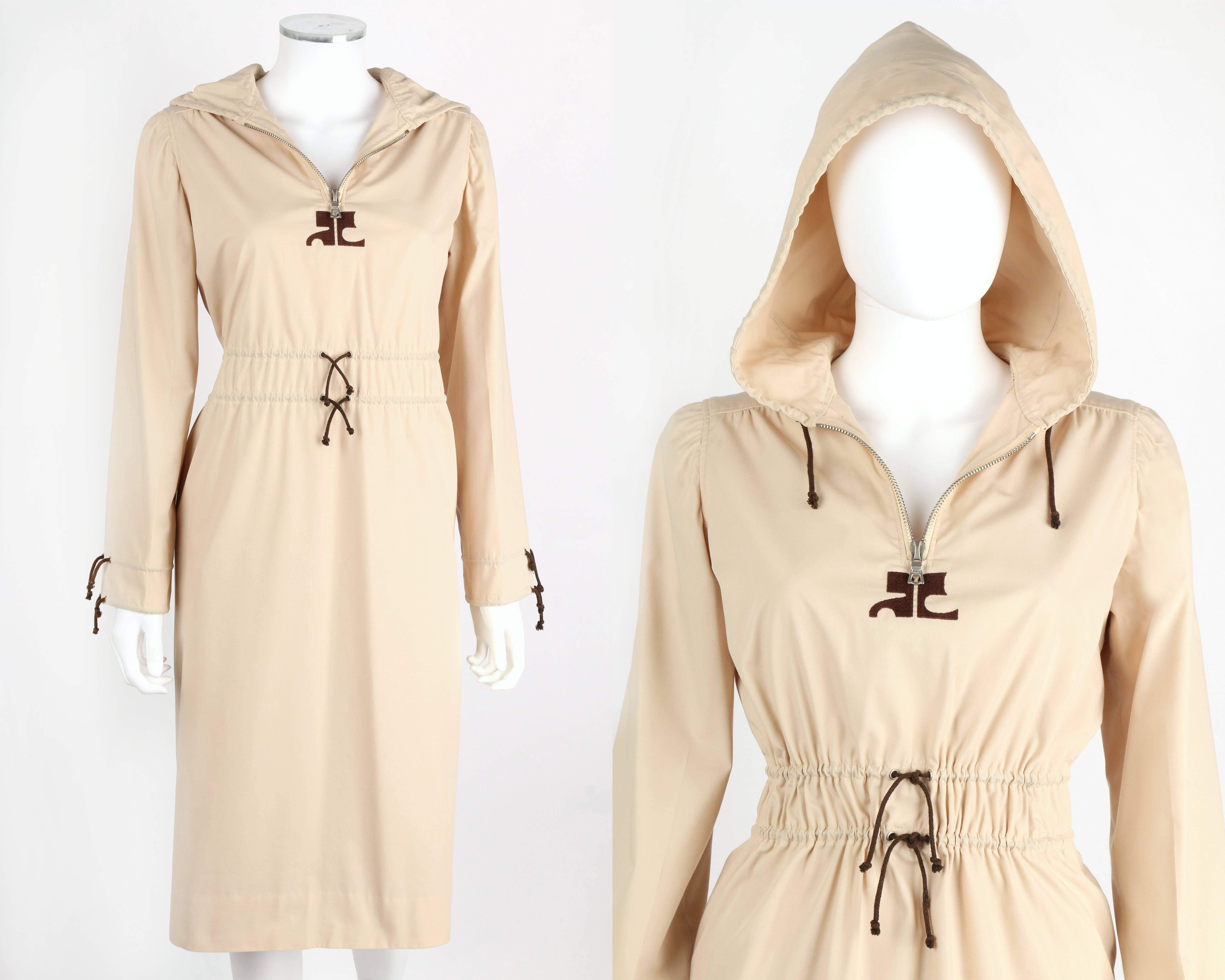 Vintage 1970's Courreges Hyperbole khaki cotton blend dress. Attached drawstring hood. Long sleeves have double drawstrings at the cuff. Double drawstrings also at the waist. Two pockets. Courreges signature logo detail at center front. Zips at