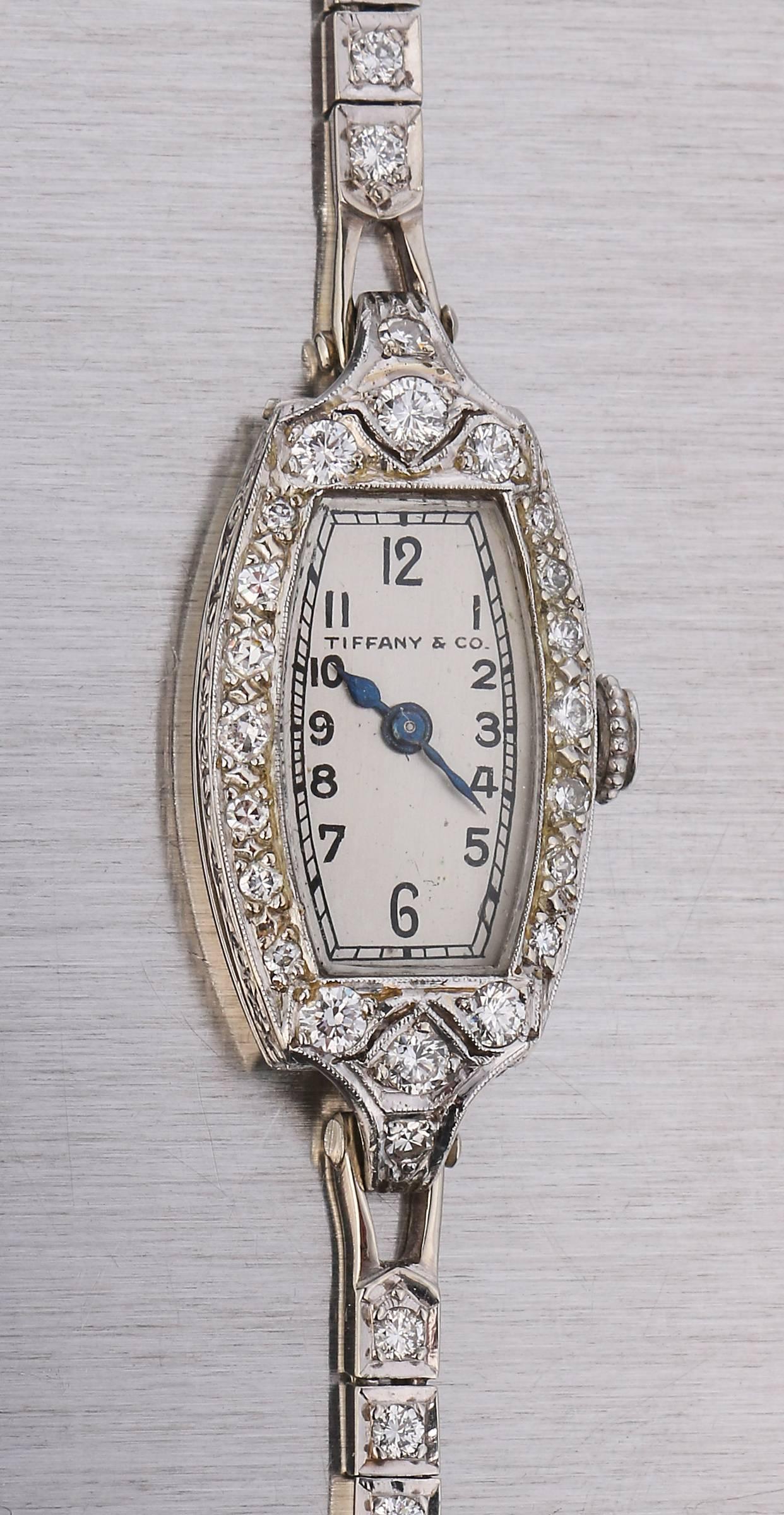 Early c.1930's Tiffany & Co. ladies diamond platinum Patek Philippe movement 14kt white gold link watch bracelet. Watch case is oblong (measures approximately 30 mm L x 16 mm W), with engraved etching on the sides, etched floral design crown, and