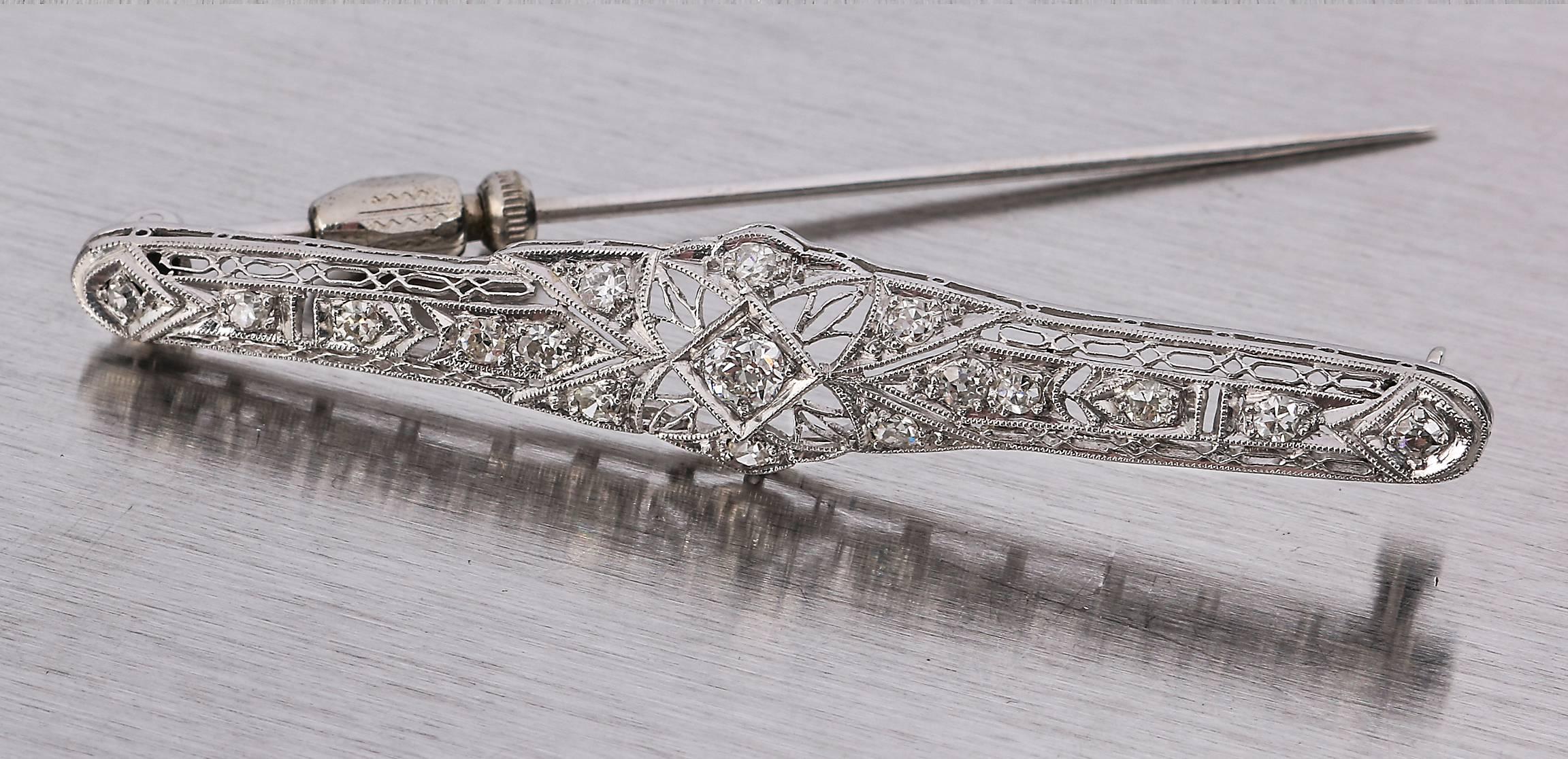 Antique Victorian / Edwardian, 1910-1915, fine platinum diamond filigree bar pin. Center Old European cut diamond (approximately .17 Ct) illusion setting in an open foliate filigree design metal with fine beaded edges. Diamond is graded as G/VS1.