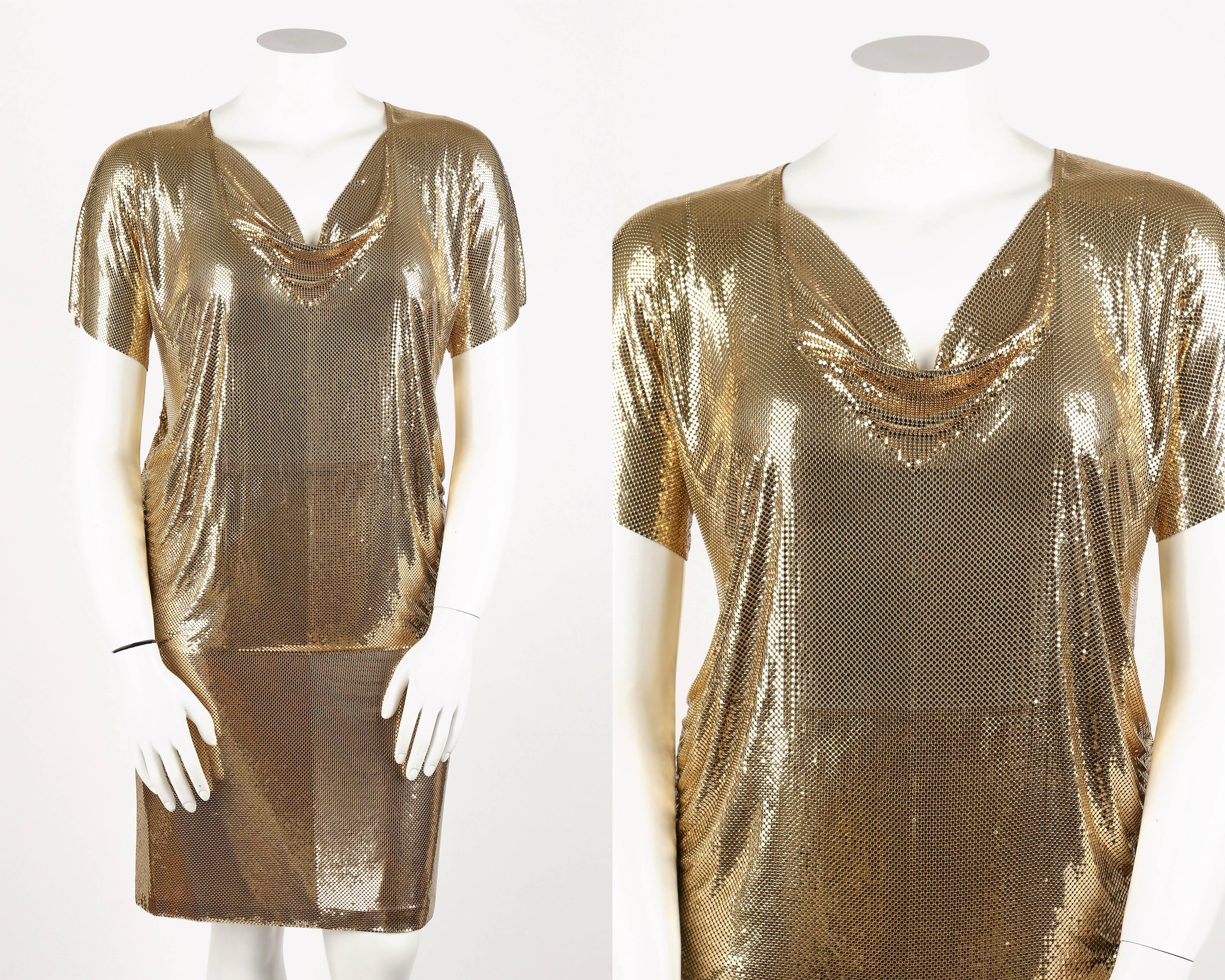 Vintage c.1970's Whiting and Davis two piece gold metal mesh cowl neck top and skirt set. Short dolman sleeved top. Cowl neckline. Gathered side seams. Center back zipper closure with hook and eye at top. Straight skirt has adjustable grosgrain
