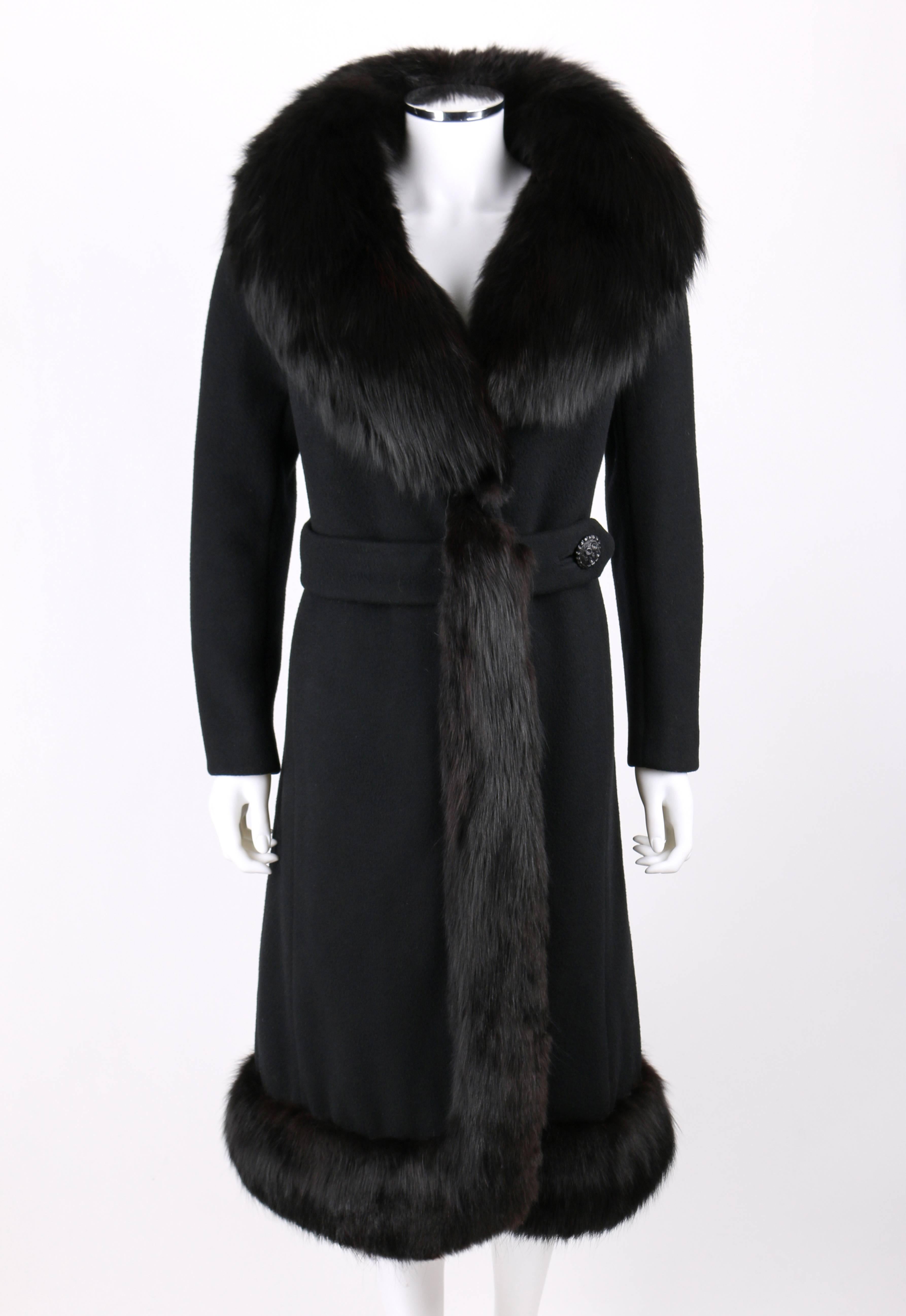 Vintage c.1960's Femainella (originally sold at Robert Hyman) black fox trim wool long coat. Large collar with fox fur trim. Fur trim continues down right side opening and hem. Center front cross over belt closure buttons and snaps. Long sleeves.