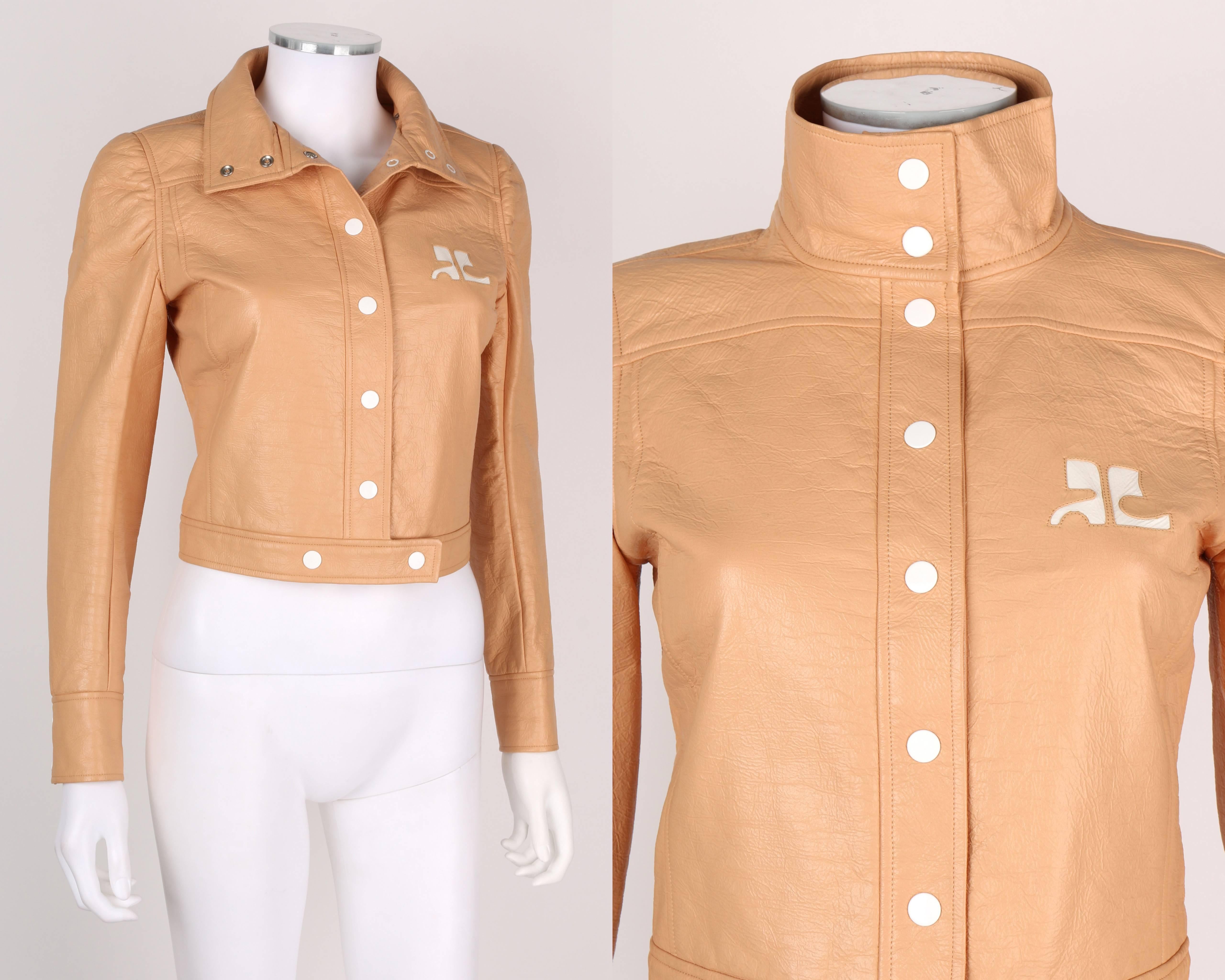 Vintage c.1970's Courreges Paris tan vinyl jacket. Long sleeves. Mock neck. White snap detailing at cuffs. Courreges 