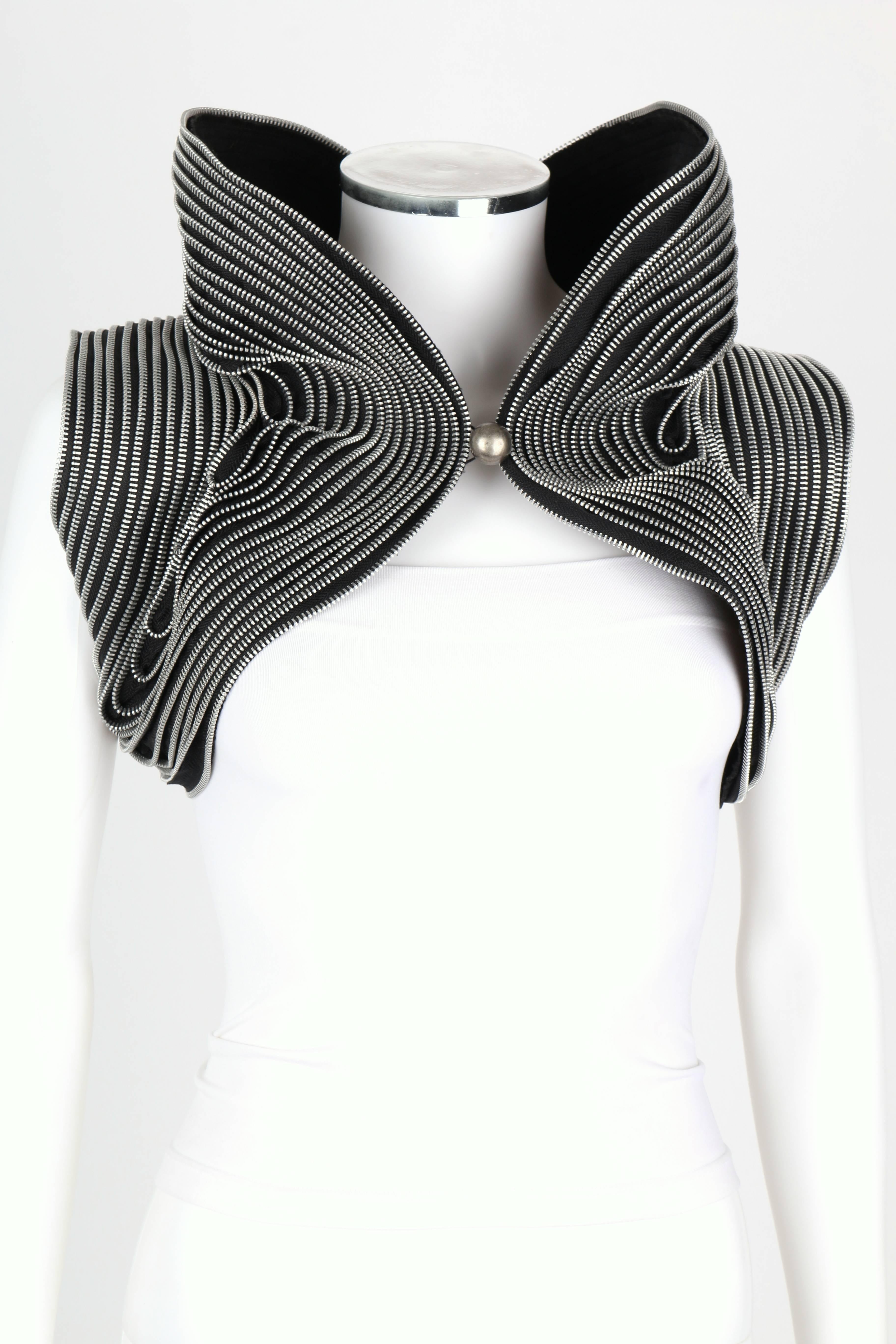 Sohung Designs by Sohung Tong c.2010 hand made black and silver zipper trim embellished bolero vest. Dramatic structured high collar. Single silver button front closure. Sculpted symmetrical back. Identical piece worn by Carrie Underwood on American