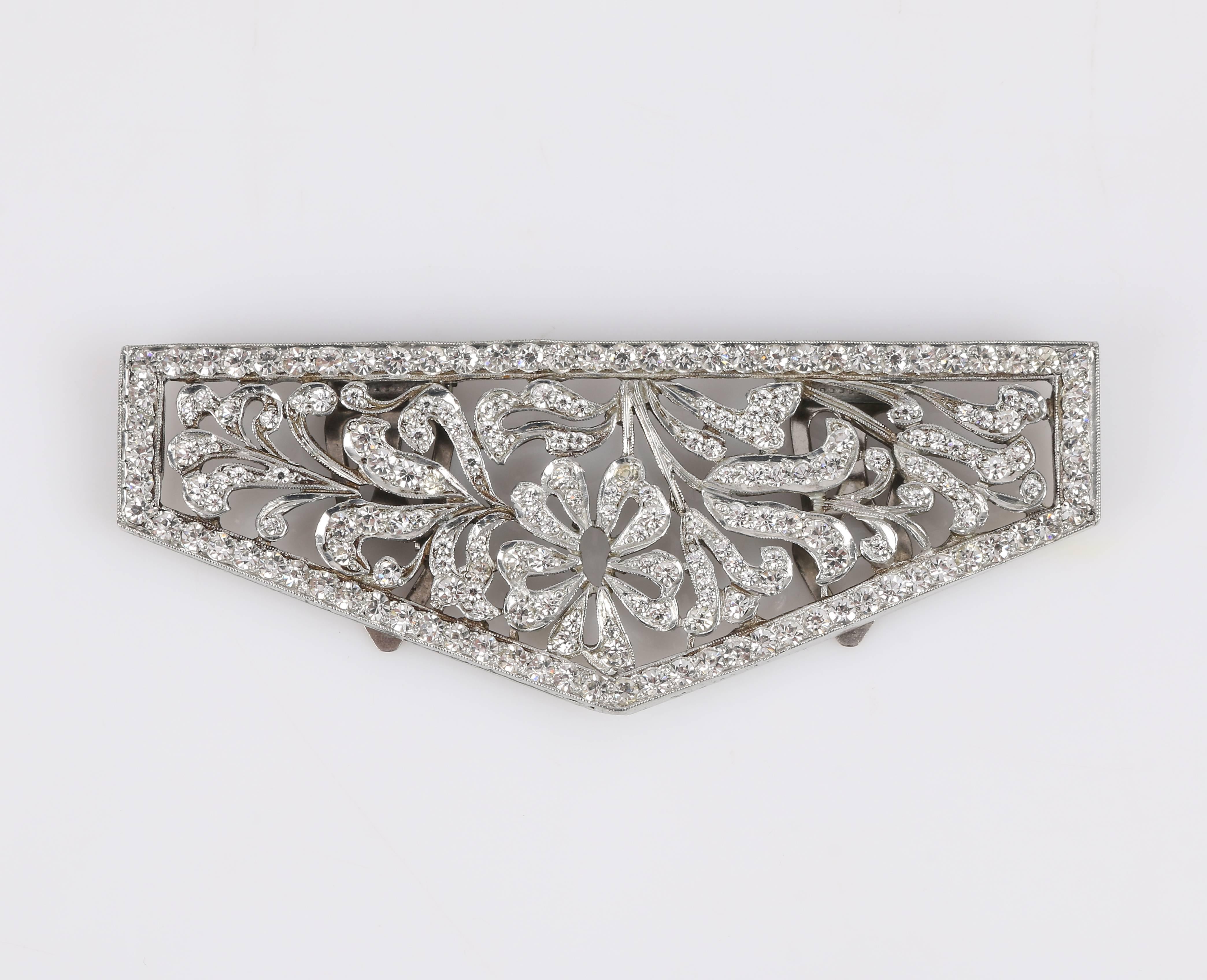 Vintage c.1930's floral open work cut steel silver-tone dress / fur clip. Elongated pentagon shape with rhinestone crystal boarder. Open work rhinestone embellished floral detailing. Two hinged three prong clasps at back (measuring approximately 1