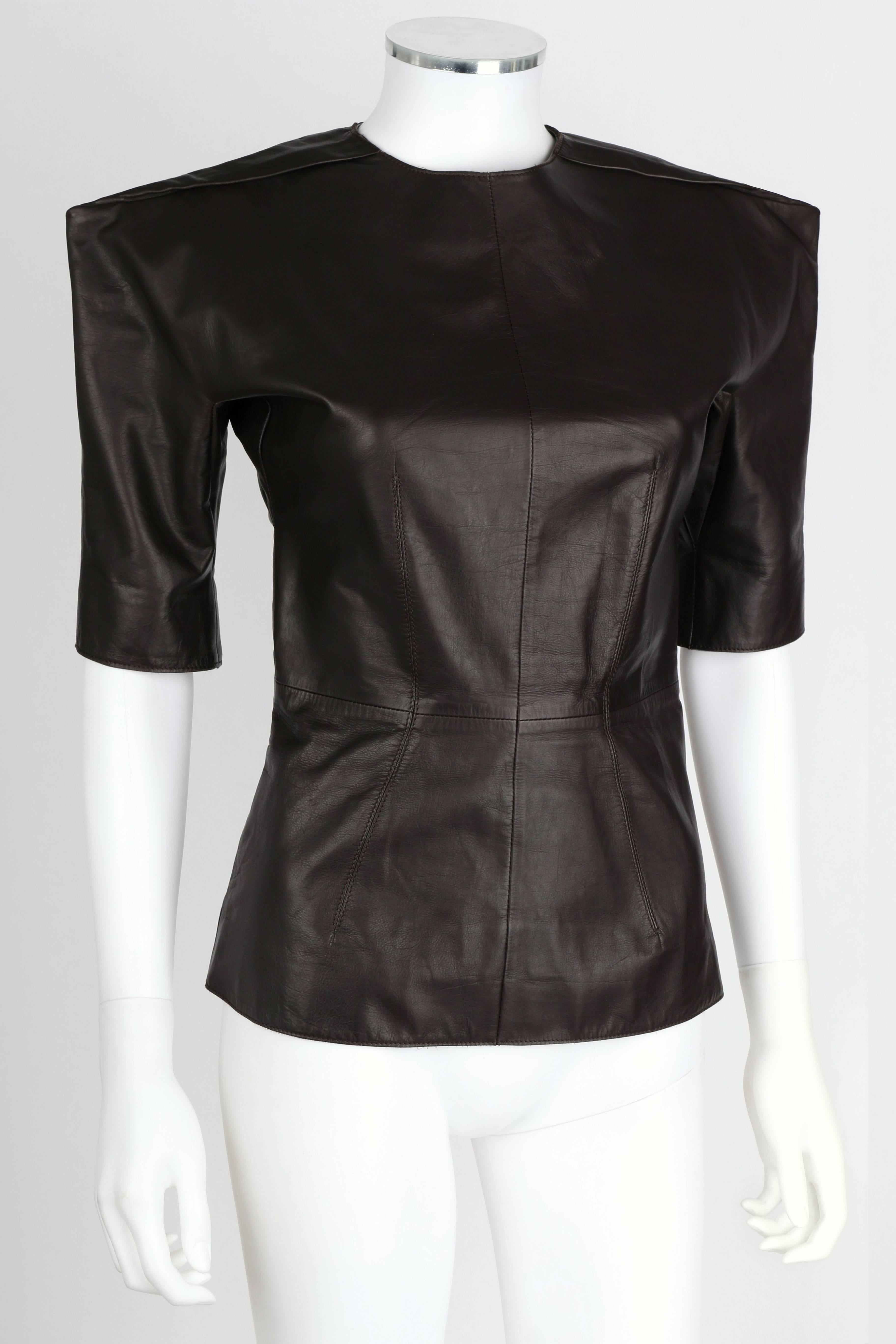 Lanvin F/W 2010 runway dark brown calf leather top. Exaggerated, structured shoulders. Mid-length sleeves. Tonal stitching and silk lining. Waistline darts. Two way separating zipper in back. Black ribbon separating tape. Marked Fabric Content: