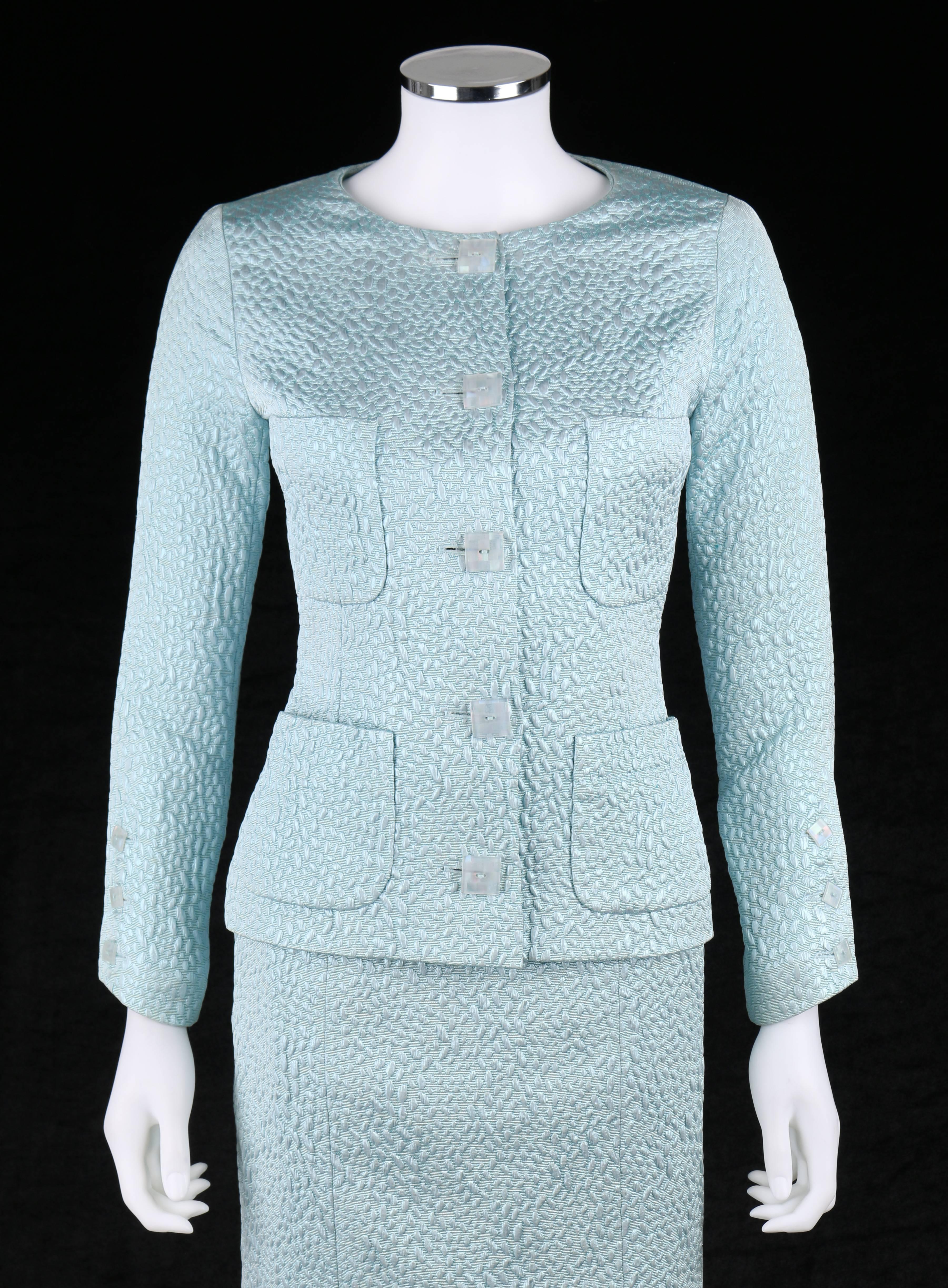 Vintage Chanel Boutique c.1980's light blue metallic skirt suit. Light blue metallic abstract oval matelasse fabric. Long sleeve jacket with three pearlized square button closures at cuff. Five center front button closures. Four front rounded patch