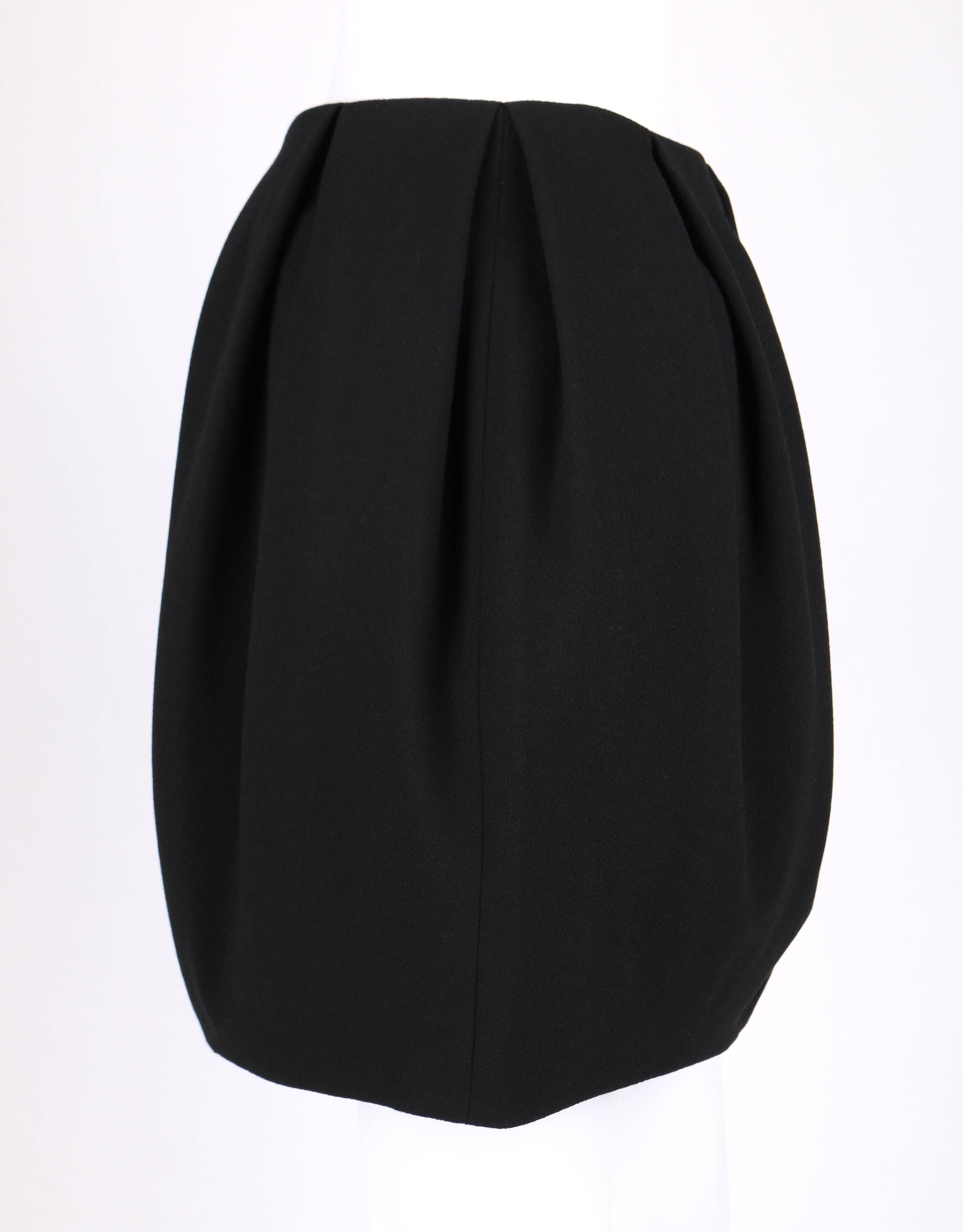 Alexander McQueen Autumn/Winter 2012 black wool crepe mini skirt. Box pleated waistline. Side invisible zipper with hook and eye closure at top. Fully lined. Marked Fabric Content: 
