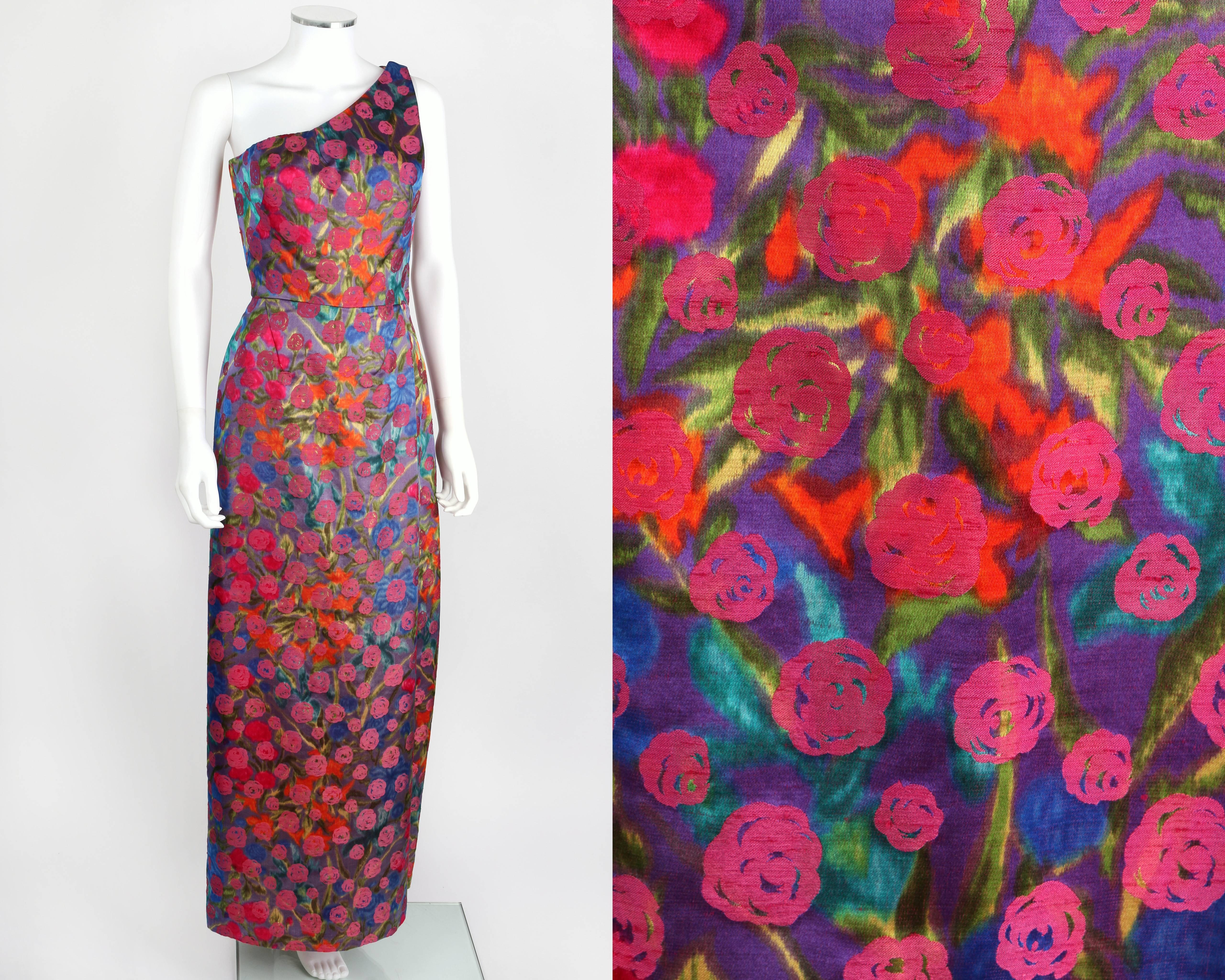 Vintage Bergdorf Goodman early 1960's floral brocade one shoulder evening dress. Multicolor painterly floral print with pink flower pattern overlay. Single pleat at side front and back of skirt. Metal zipper closure at side. Three hook and eye