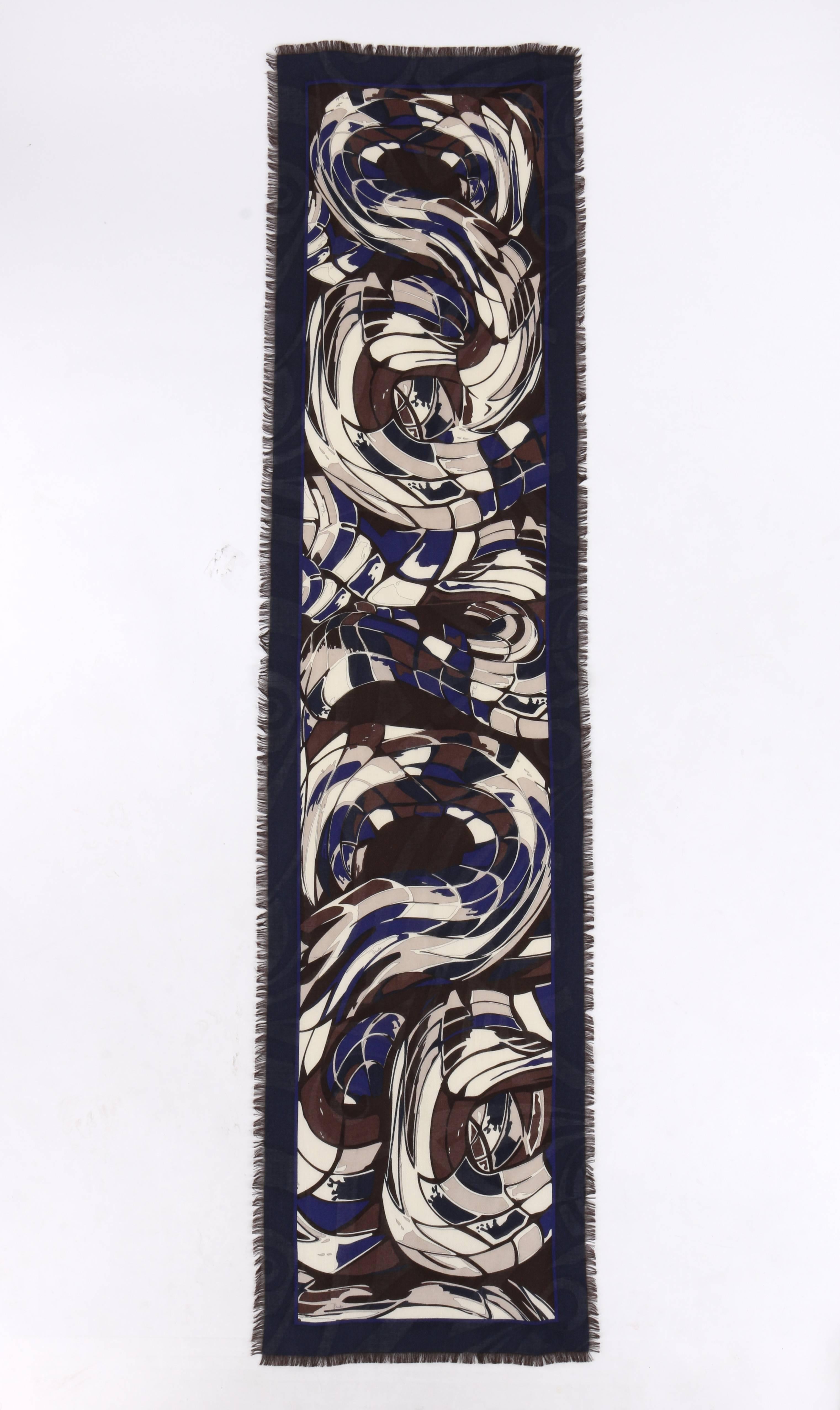 Emilio Pucci wool and silk blend oblong scarf. Multicolor abstract signature print in shades of blue, brown, cream, and black. Raw fringe edge. Oblong shape. Unmarked Fabric Content: Wool / Silk blend. Measurements:

Length: 68.5" (excluding